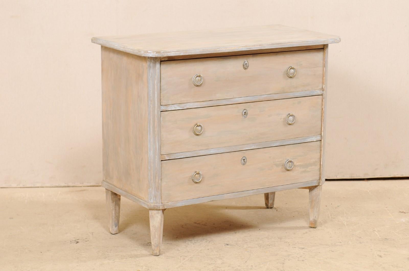 A Swedish Gustavian style chest of drawers from the mid-20th century. This vintage chest from Sweden, designed in typical Gustavian style, features a simple, clean design with canted front side posts adorn with fluted carving. The top is slightly