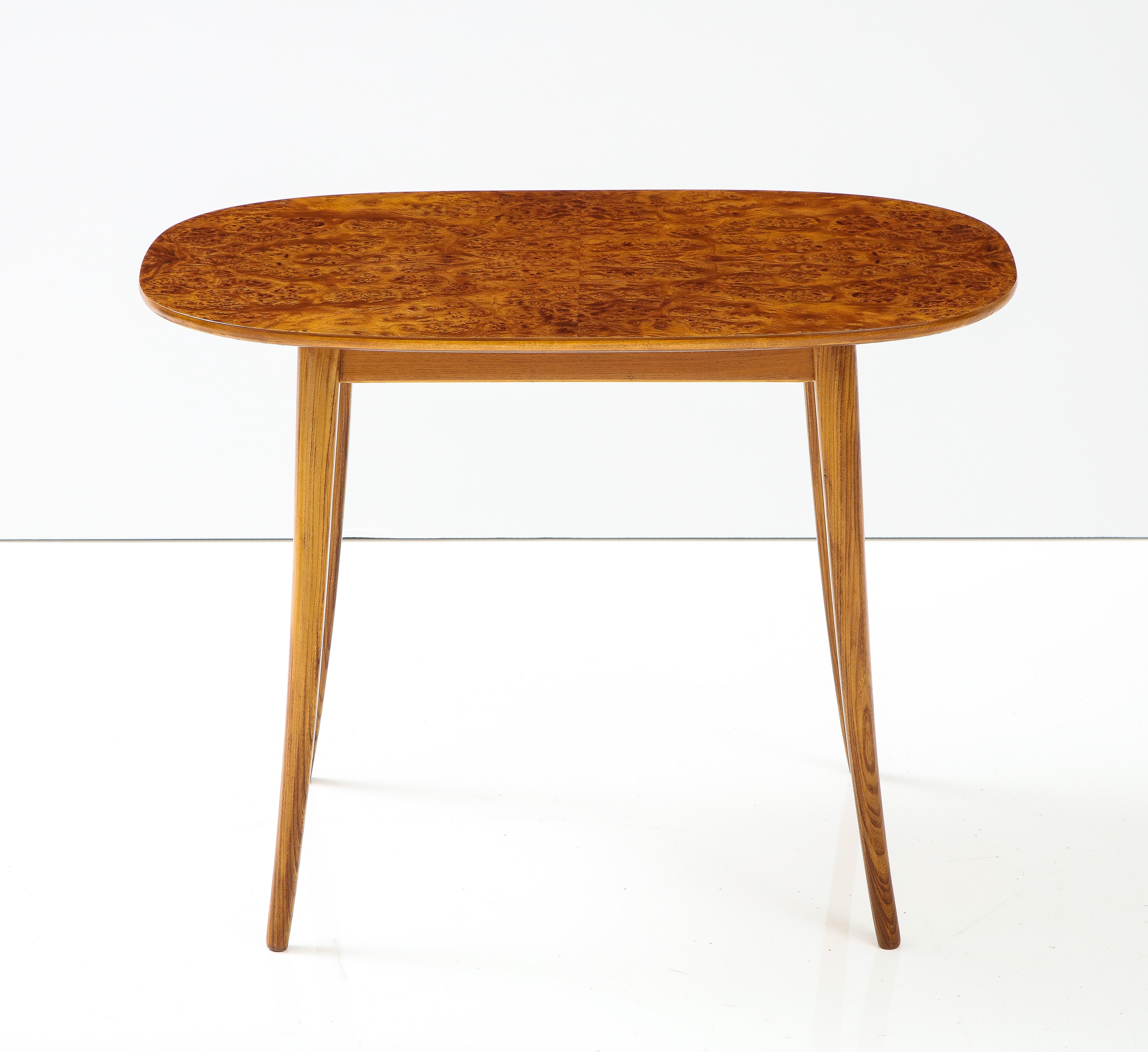 A Swedish Modern elm root side table, circa 1940s, the oblong figured elm root top raised on sabre legs.