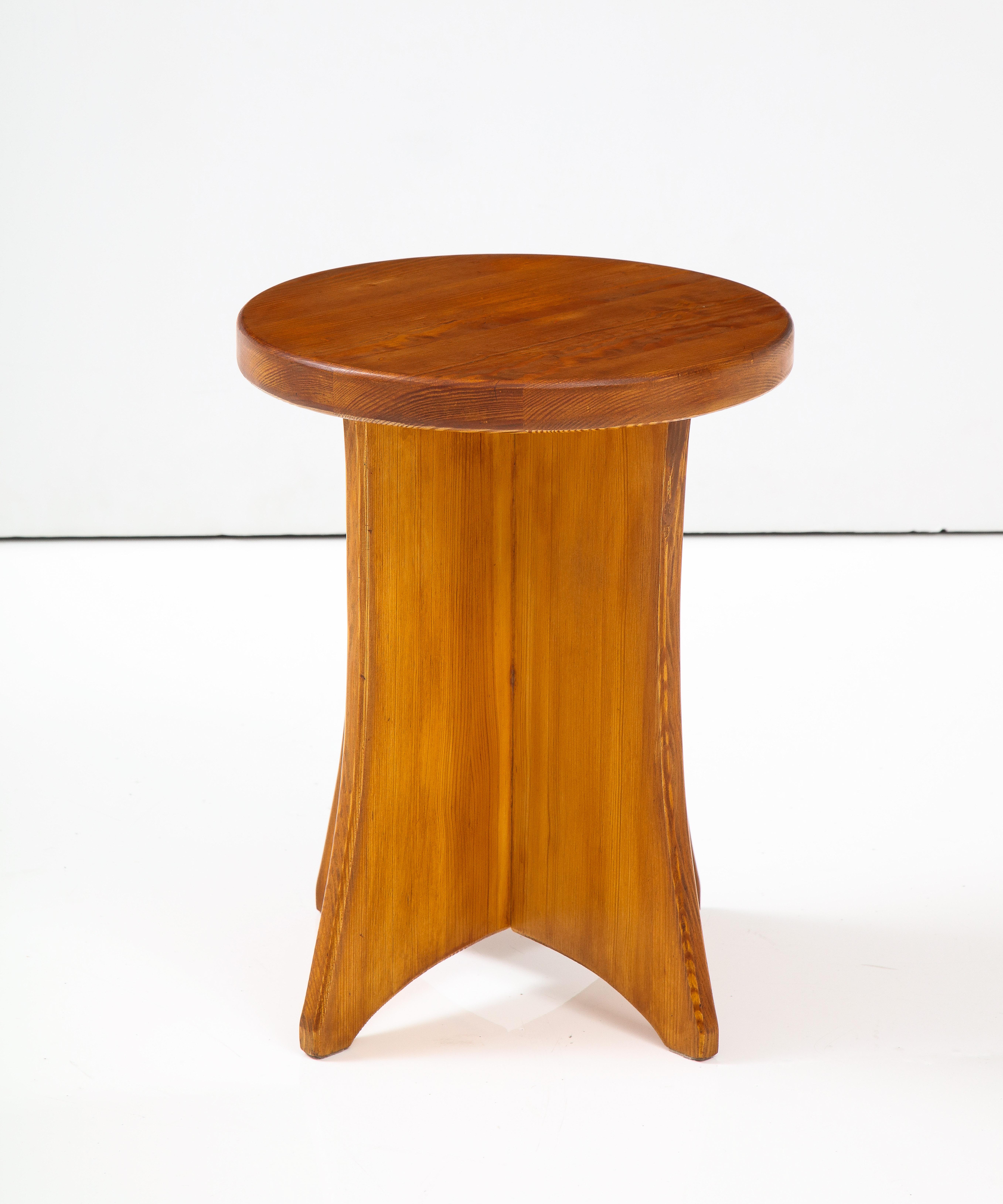 A Swedish Modernist pine side table or stool, Circa 1960s, with a solid circular top raised on four in-curved supports.

