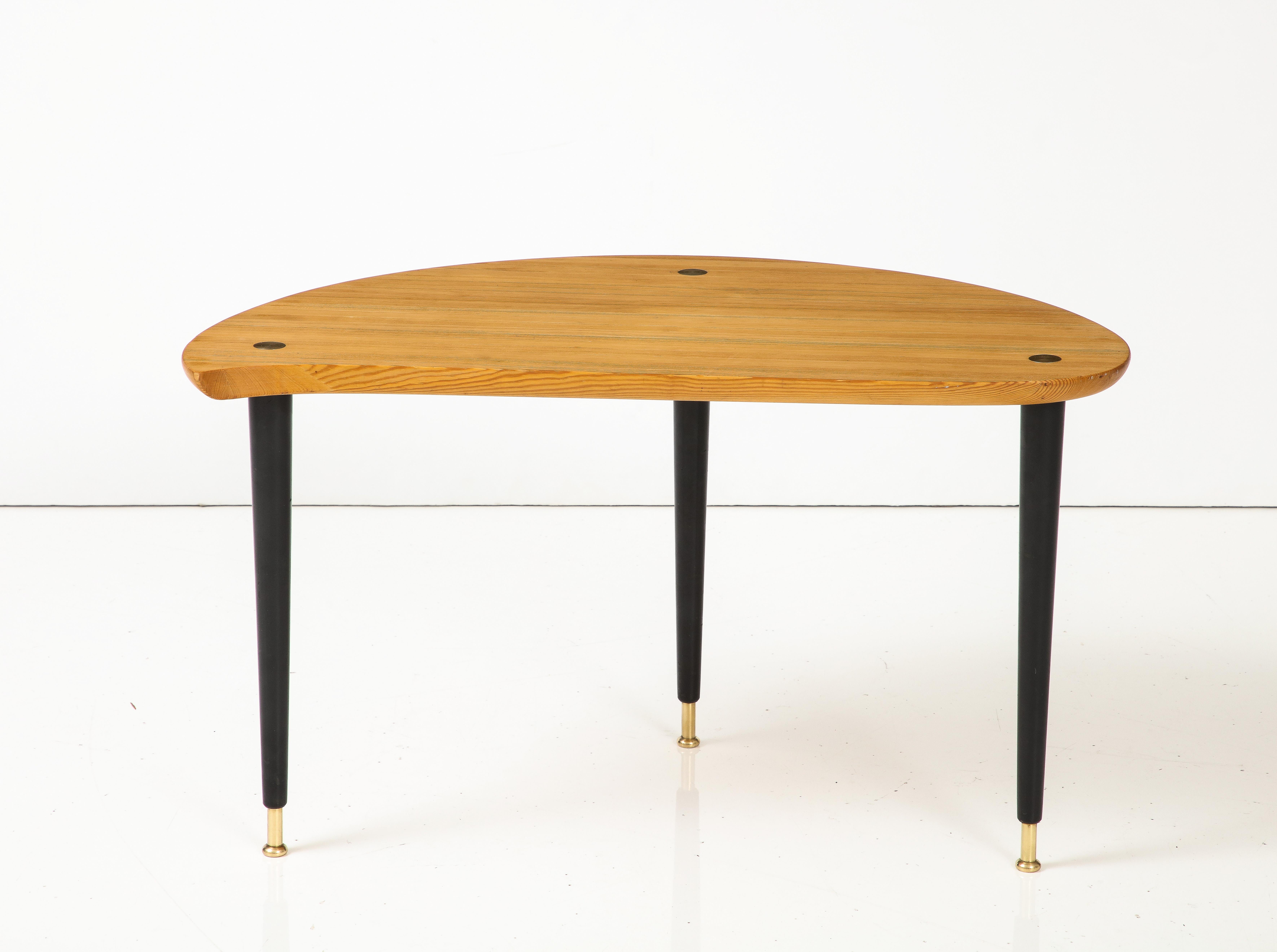 A Swedish pine and ebonozed table with brass details, produced by Karl Andersson & Söner, Huskvarna. Sold under the product line called Svensk Fur, the asymmetric pine top raised on ebonized legs headed and ending with brass details.
Designed by
