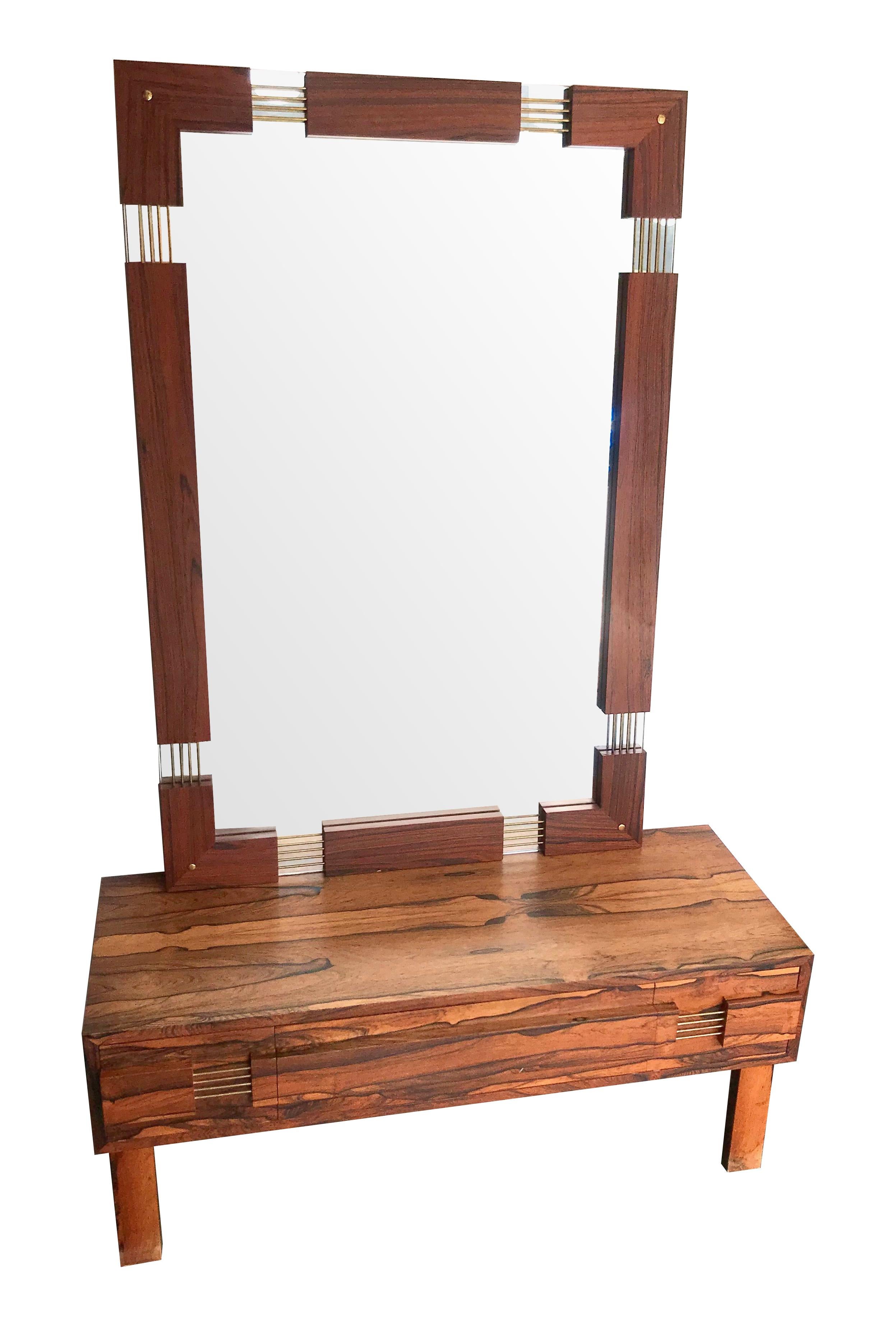 A Swedish rosewood low chest of drawers / dressing table with matching wall mirror by AB Glas & Tra, Sweden, with 3 drawers in the dressing table with brass detail handles and matching wall mirror with rosewood frame and and matching brass detail.