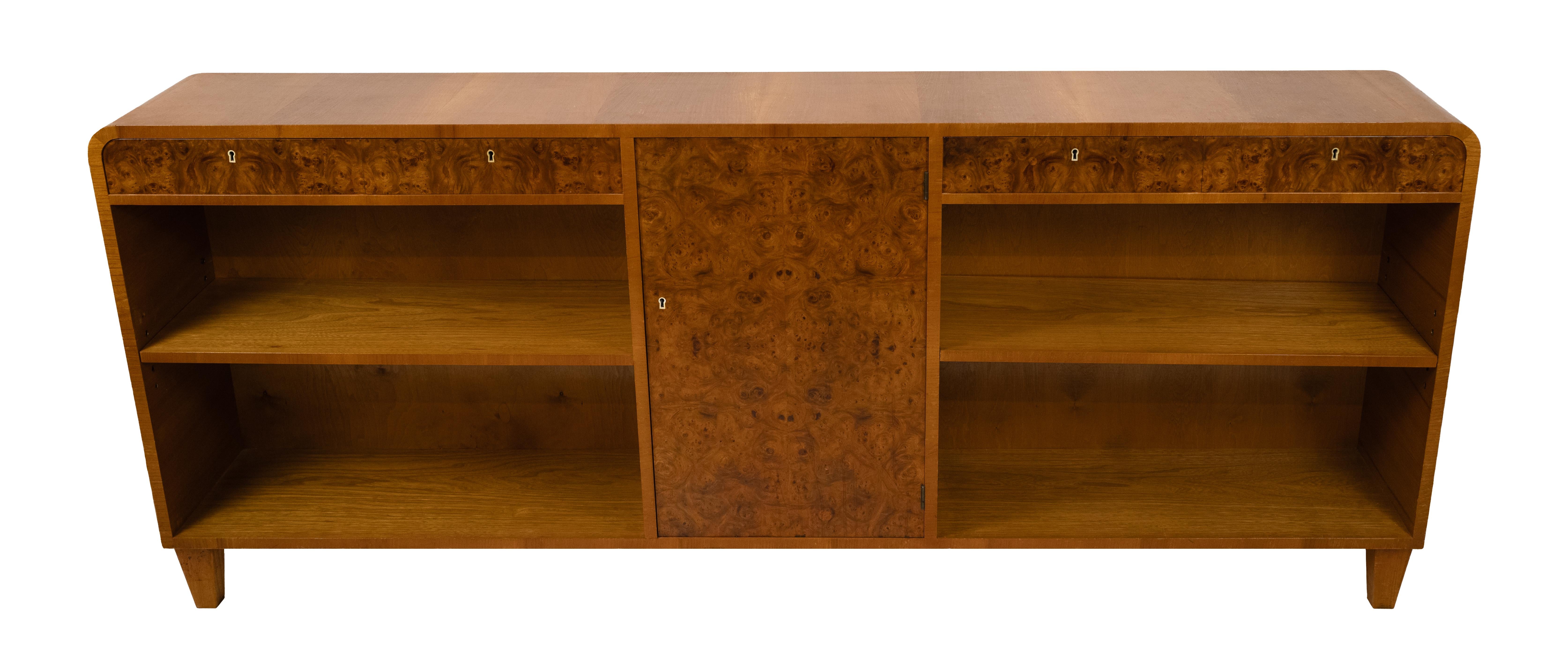 A Swedish Modern low cabinet with a waterfall edge. The cabinet doors and drawers in highly figured birch, supported by squared and tapered legs. Made by Axel Ståhls Möbelfabrik AB, circa 1930.