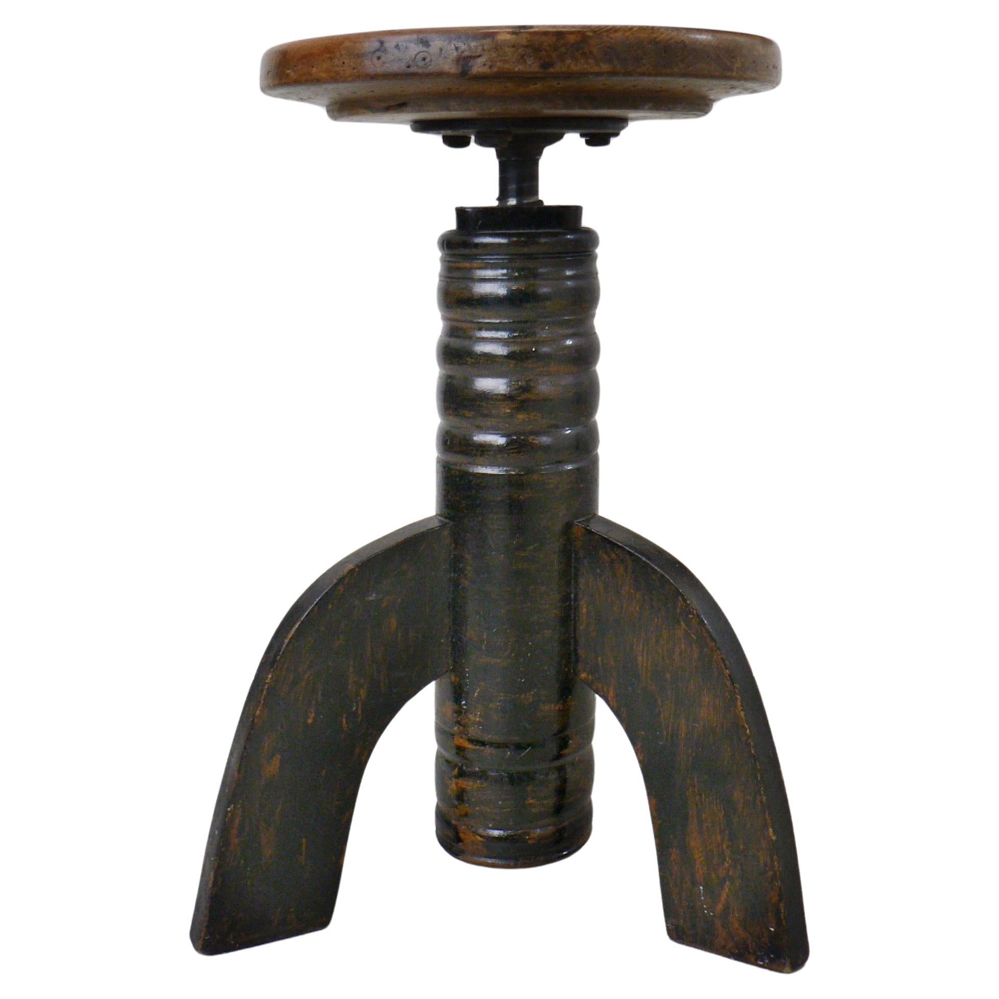 A swiveling, height-adjustable, tripod stool from early 20th-century France.