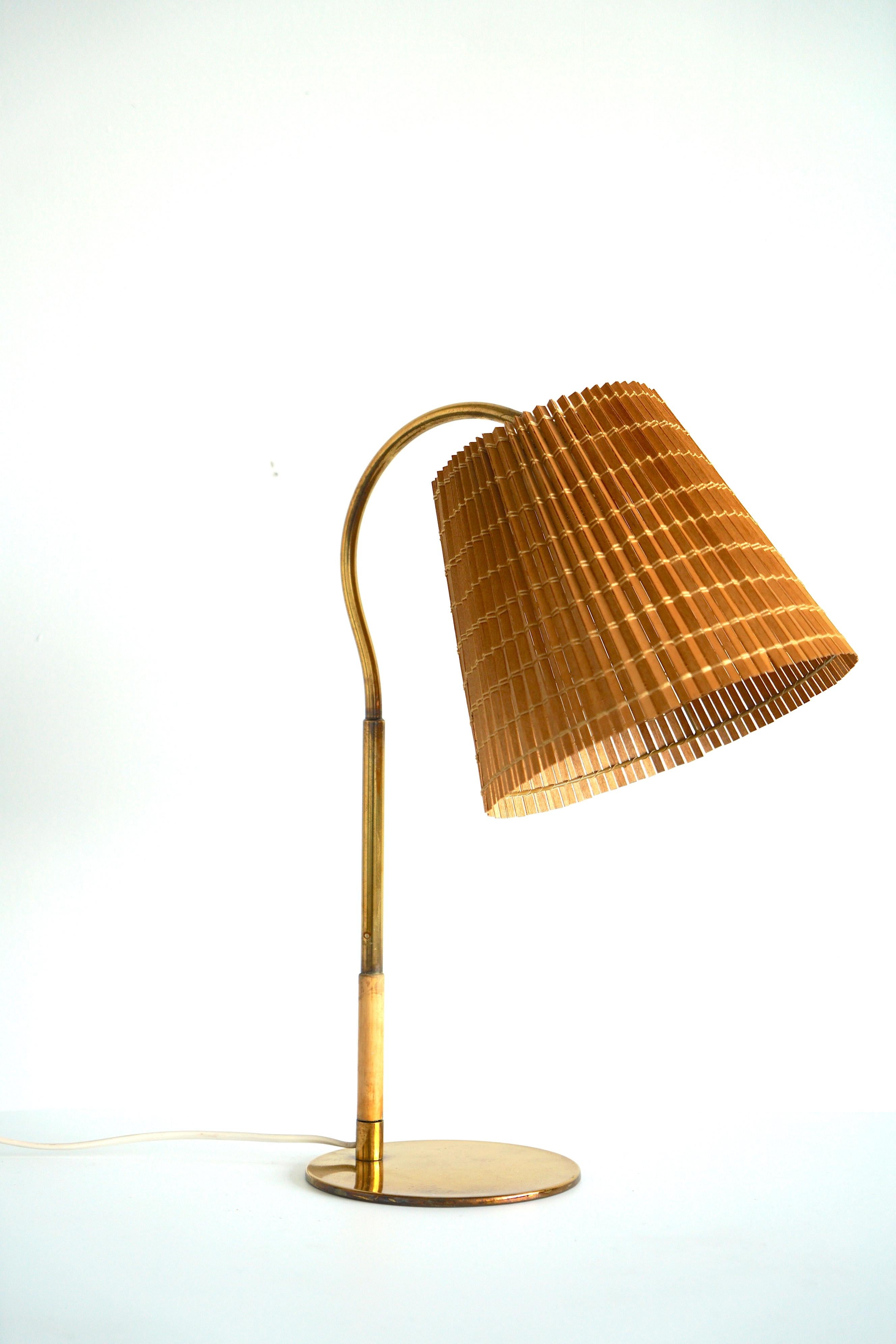Eine Tischlampe, entworfen von Paavo Tynell, Modell 9201, hergestellt von Taito Oy, um 1940/50. Poliertes Messing, Holz, mit Holzschirm. Auf dem Sockel ist 