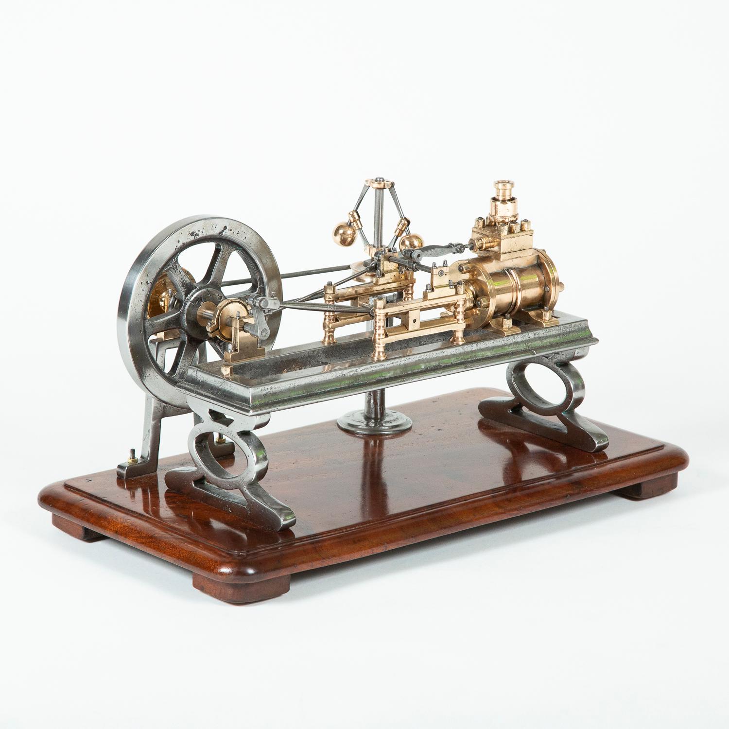 A late 19th century tabletop model of brass and steel live steam engine model of a single-cylinder horizontal mill engine, with cast flywheel and separate governor on a pedestal. 

Mounted on a period mahogany plinth.