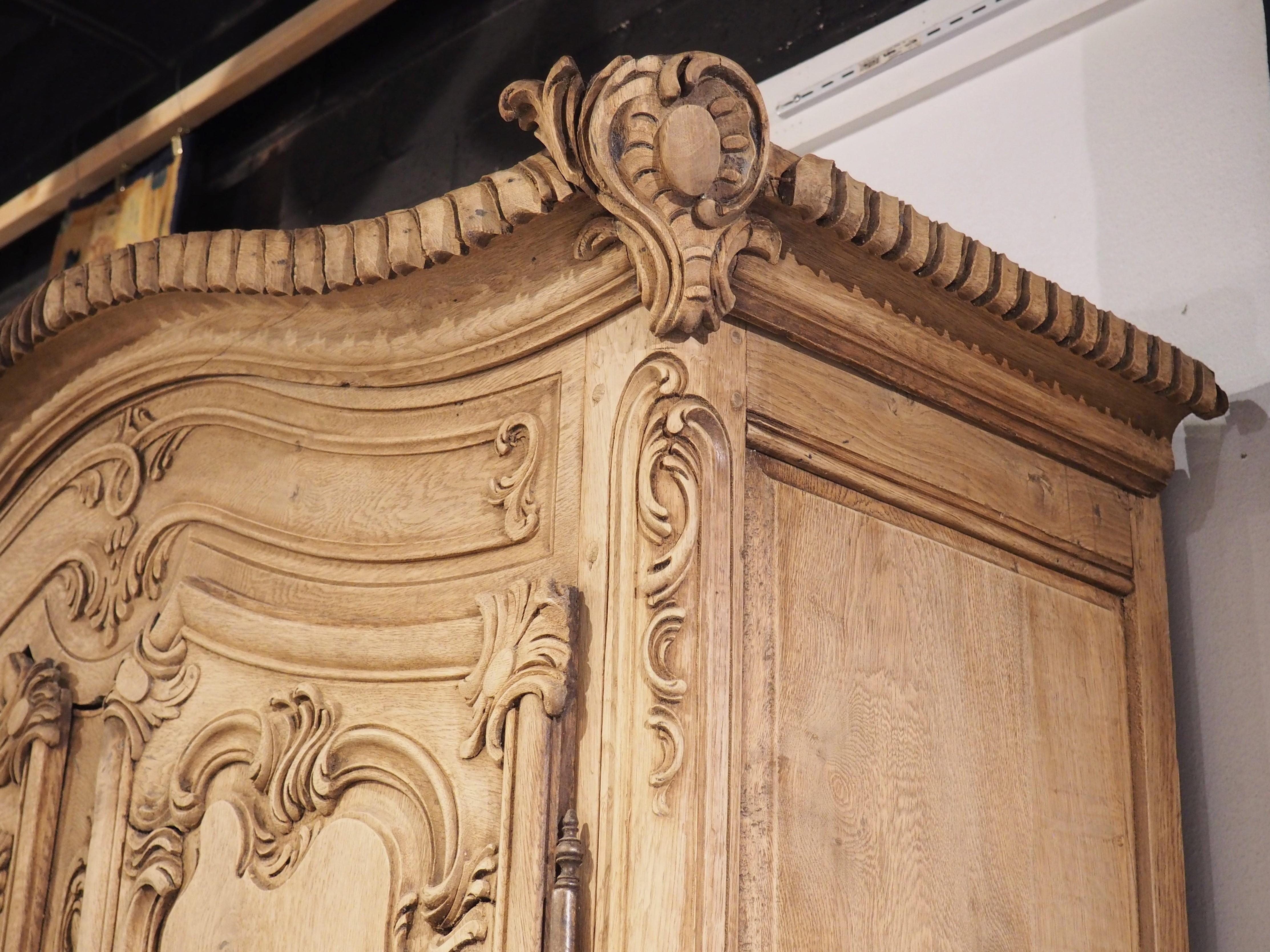 The Rocaille-inspired motifs of this bleached French armoire are deep and luxurious, indicating that it was hand-carved by a master craftsman. Equally as impressive is the construction of the various sections of oak, which have been pegged together