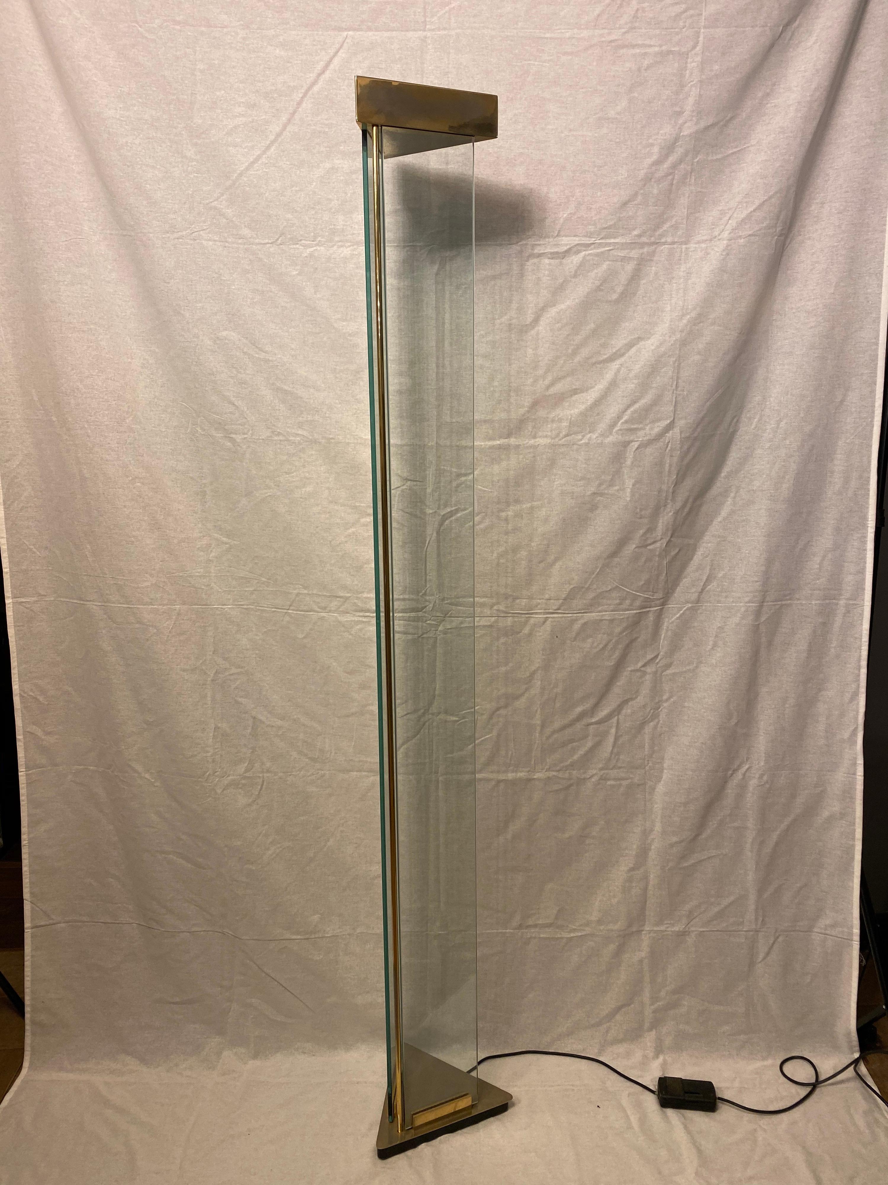A tall up lighter floor lamp, architectural in design with triangular base and top in brass, two glass panels with brass Rod support. Continental, 1970s.
