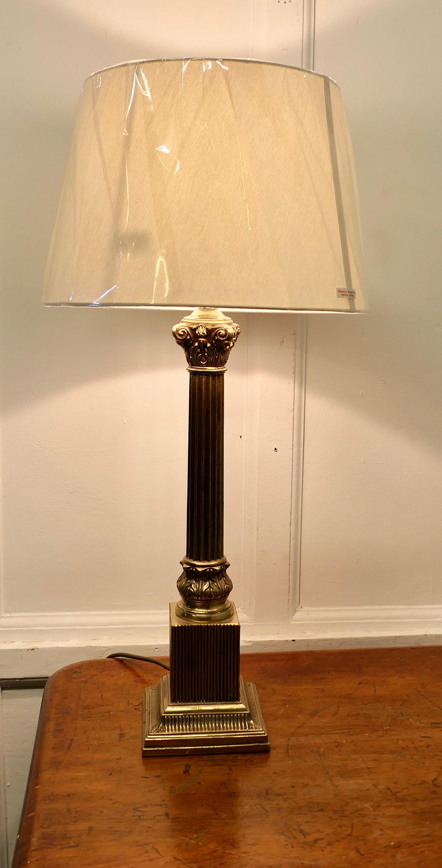 Lampe de table à colonne corinthienne en laiton  

Cette lampe est très attrayante. Elle possède une lourde colonne de style corinthien posée sur une base rectangulaire étagée. Elle est livrée avec un abat-jour en lin de couleur neutre, qui peut