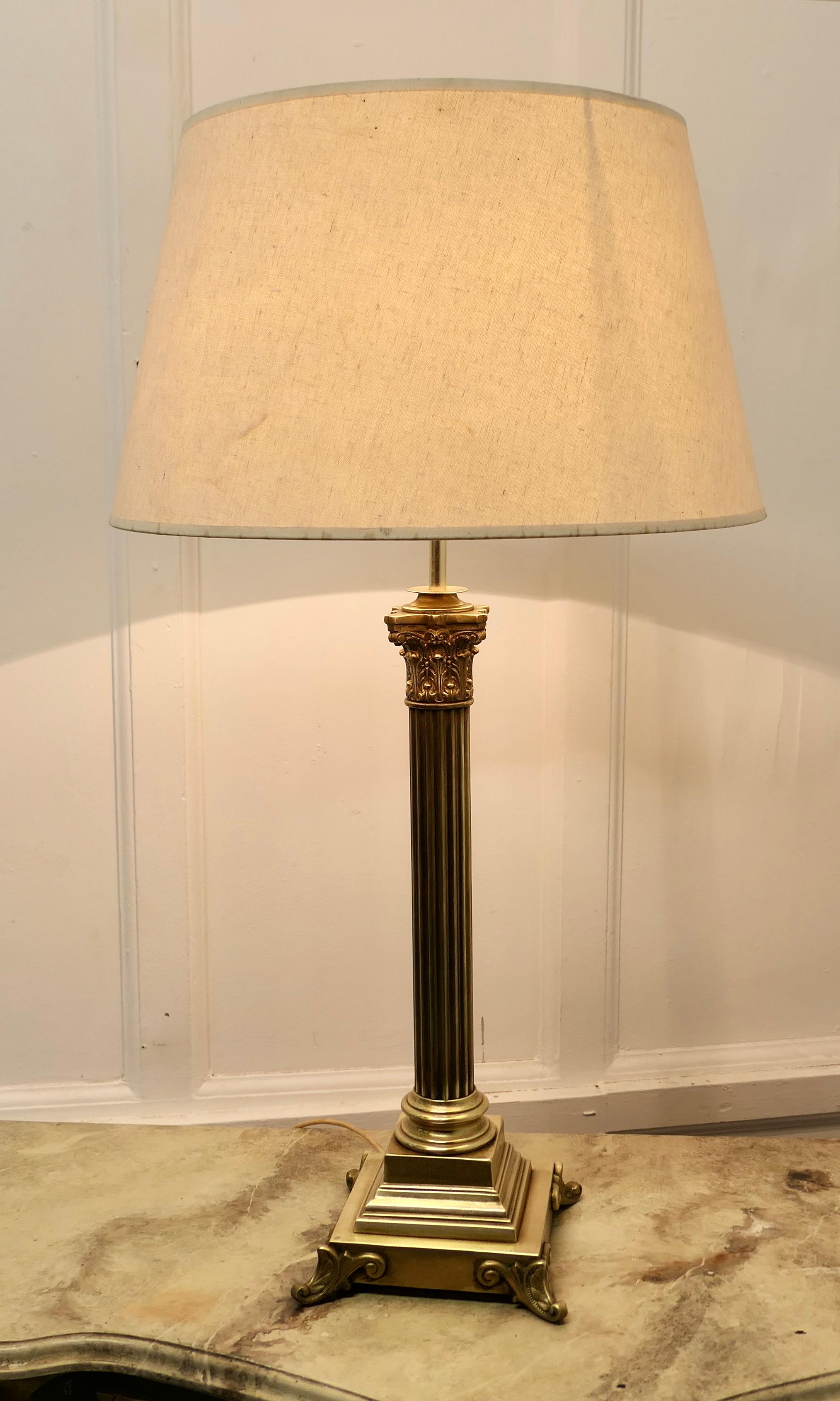A tall brass Corinthian column table lamp with shade

This is a very attractive lamp it has a heavy single corinthian style column set on a stepped rectangular base, it comes with a neutral coloured linen lamp shade, this can be included if