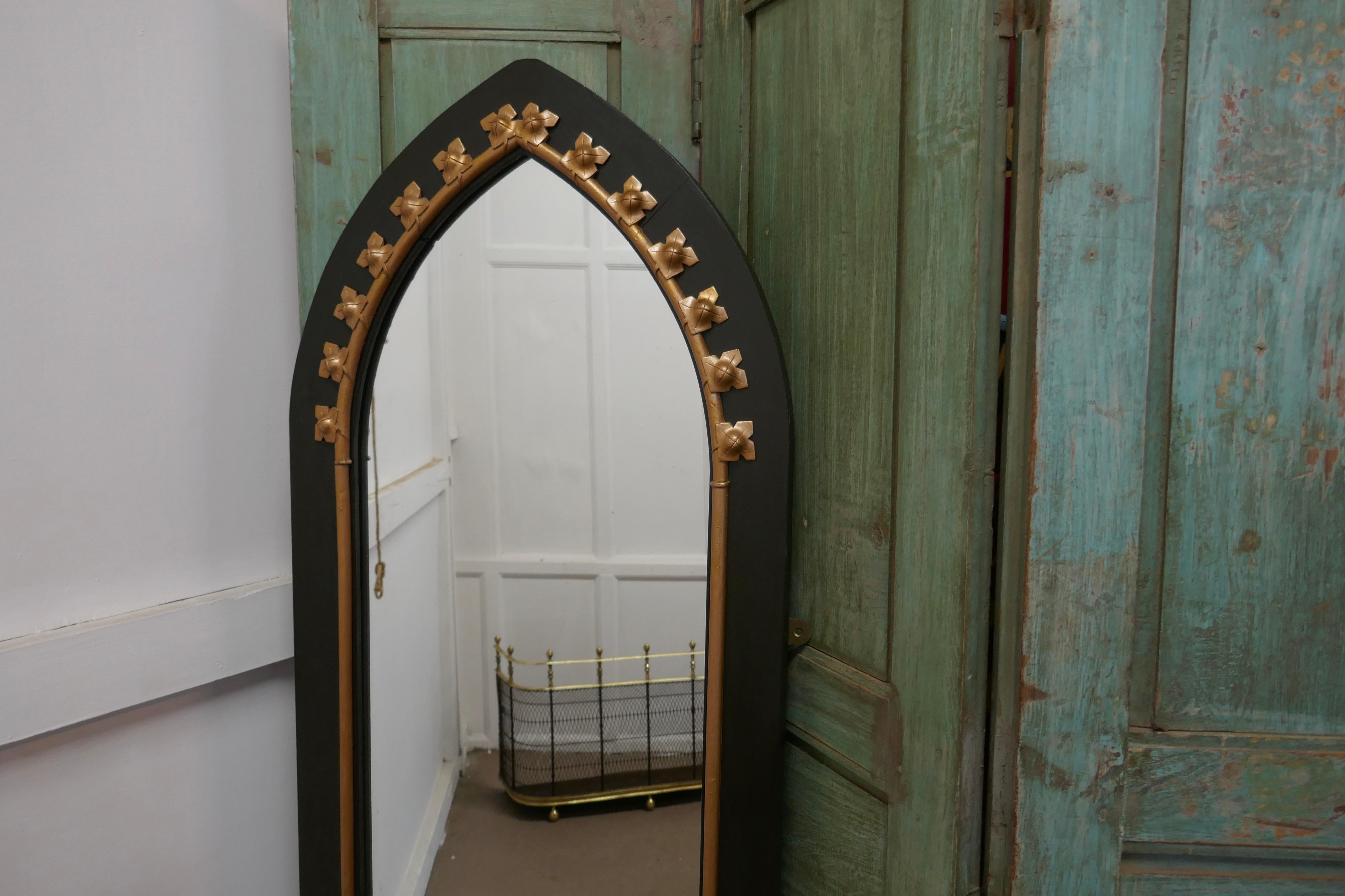 A tall console mirror, with an Arts & Crafts Gothic frame

This very tall mirror has a painted black frame declared in gold in the Gothic style
Both the frame and the mirror are in good condition,
A good decorative piece
The mirror is 68” high