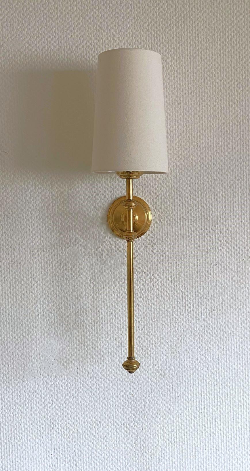 A tall Art Deco torchiere wall sconce in the style of Maison Jansen, France, 1955-1959. Very elegant design made of brass with conical off-white linen shade. It takes one Edison E14 candelabra screw bulb up to 60watt.
In very good vintage condition,