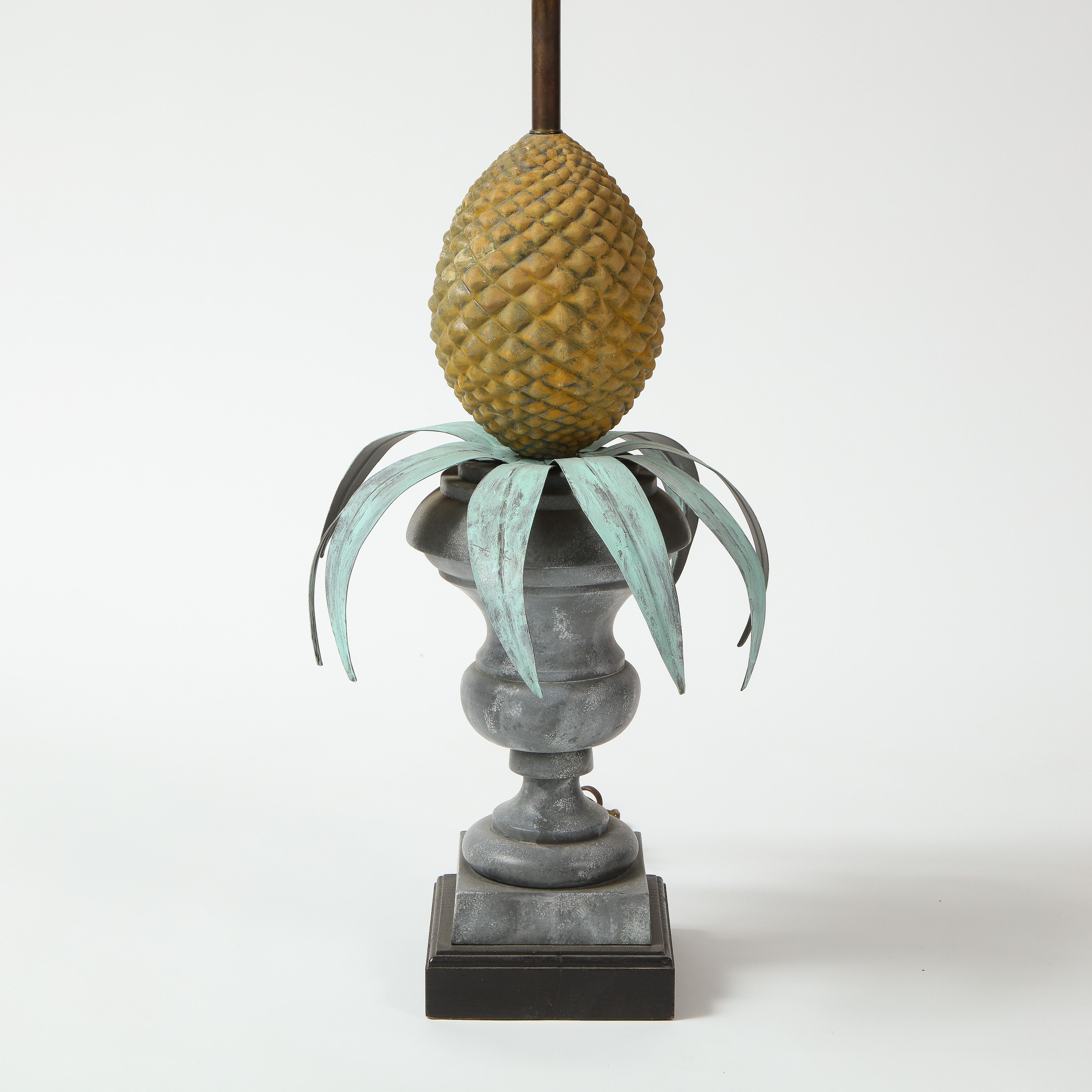 Featuring a pineapple resting on a footed urn; fitted with two bulb sockets.