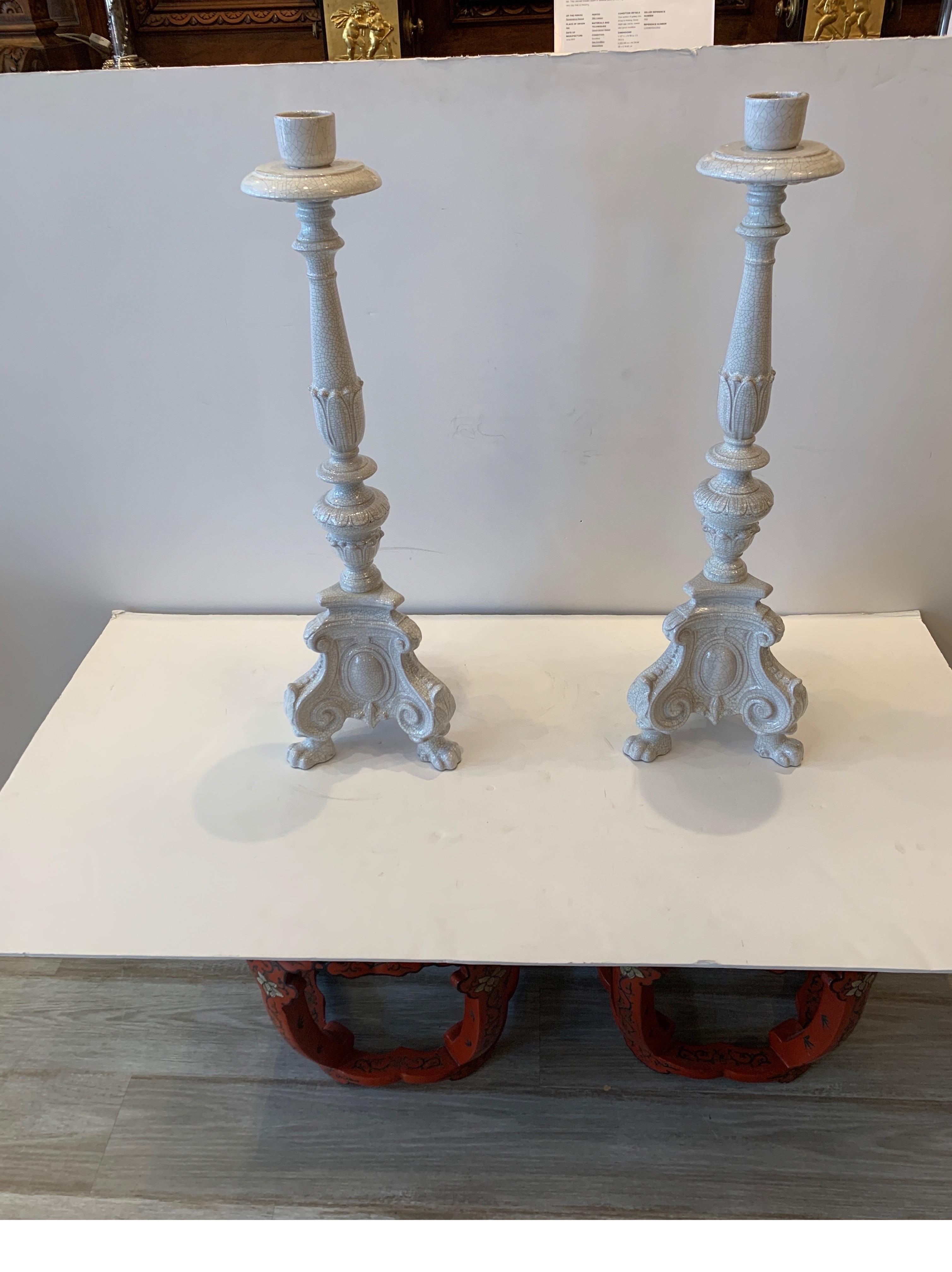 A pair of very chic Blanc-de-chine glazed tall candlesticks/ circa 1930s with a off white tin glaze with crackle finish over earthenware. 30 inches tall.