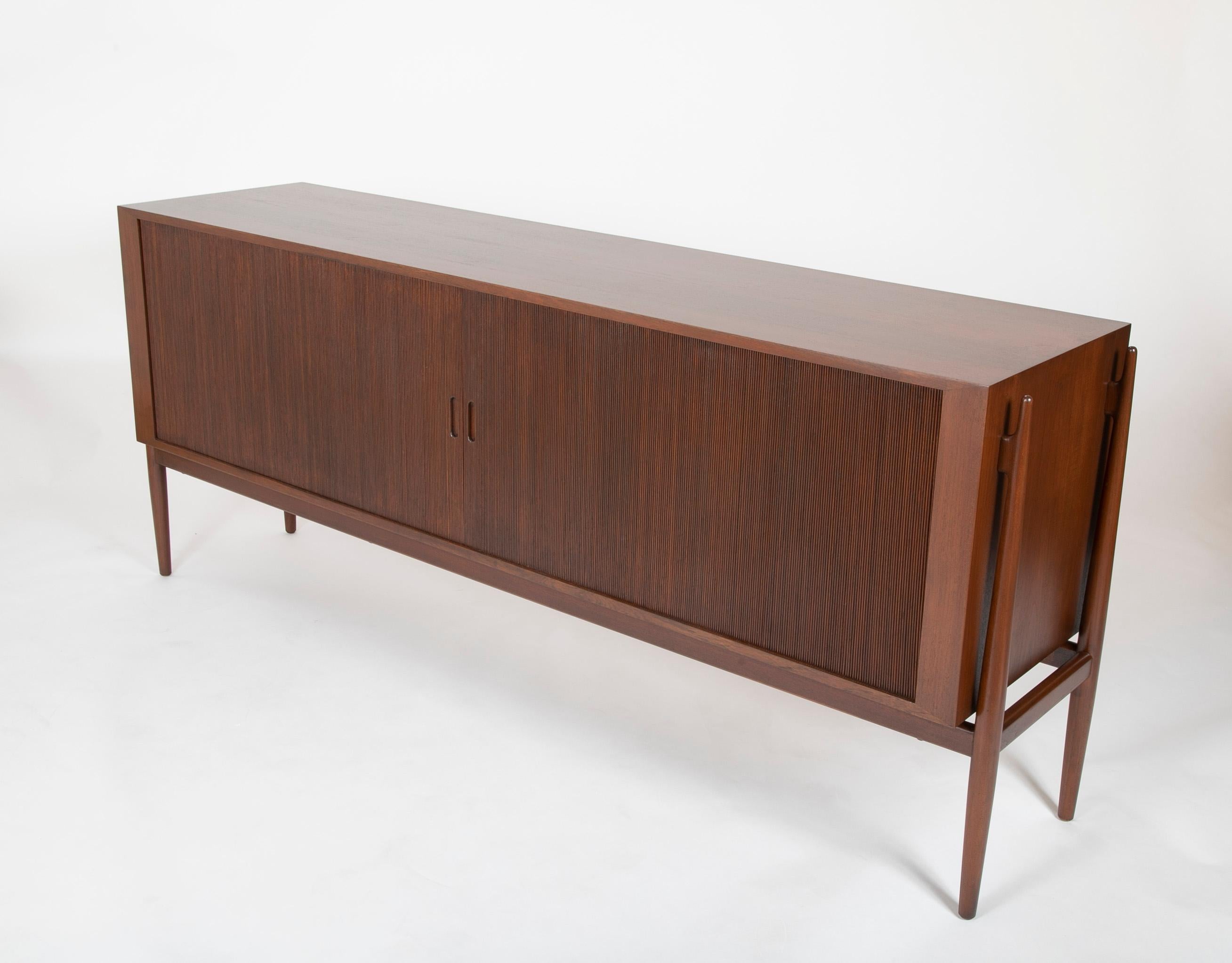 A model NV54 sideboard designed in 1954 produced by Niels Vodder. Exterior is dark brown teak and the interior cabinet is Maple. Having 8 interior drawers and a single shelf.