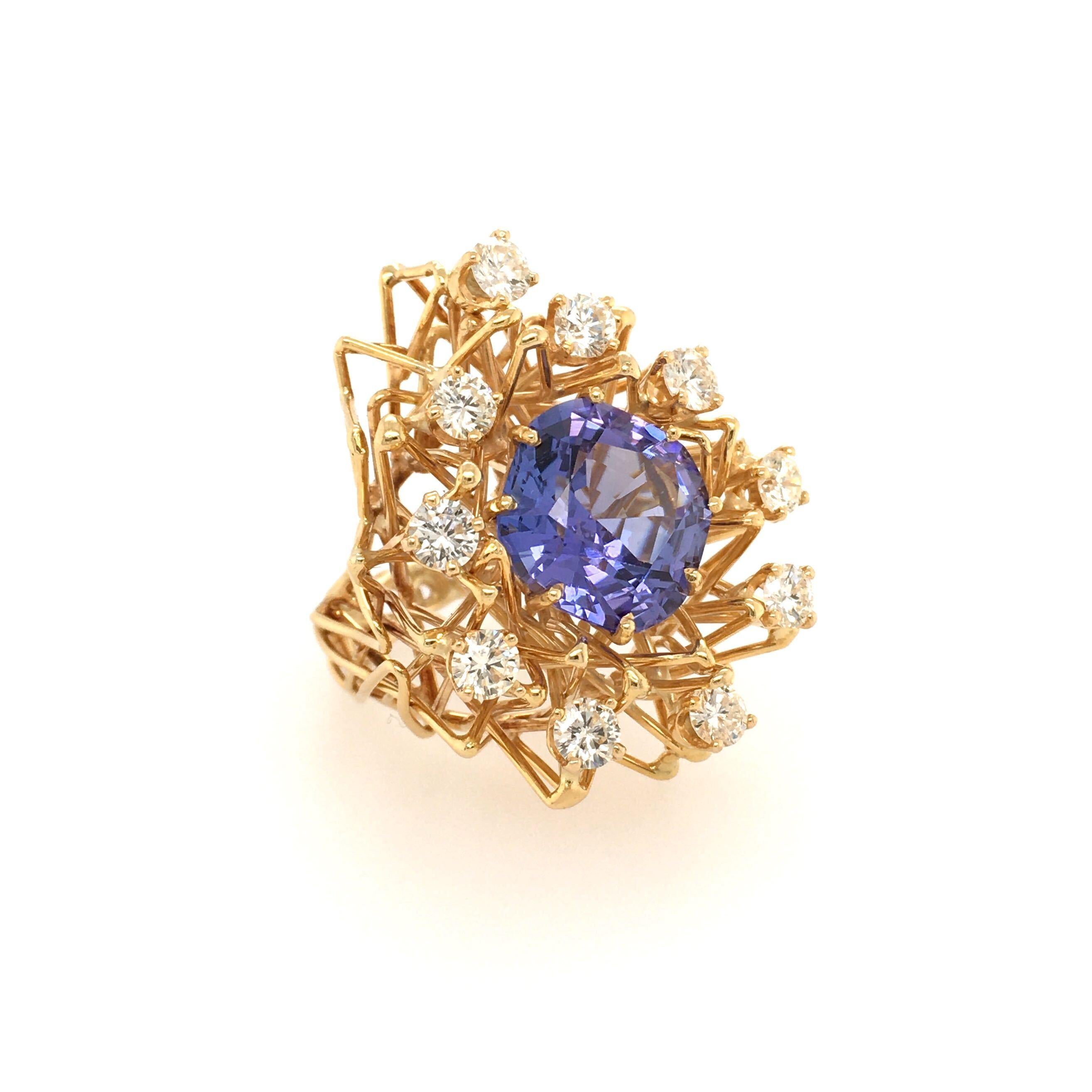 An 18 karat yellow gold, tanzanite and diamond ring, attributed to Boris Le Beau. Of openwork wire design, centering a cushion cut tanzanite, measuring approximately 13.0 x 13.0mm, enhanced by circular cut diamonds. Ten (10) circular cut diamonds