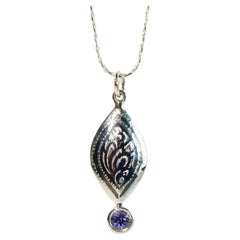 Un pendentif en argent avec une tanzanite ronde de 5 mm 