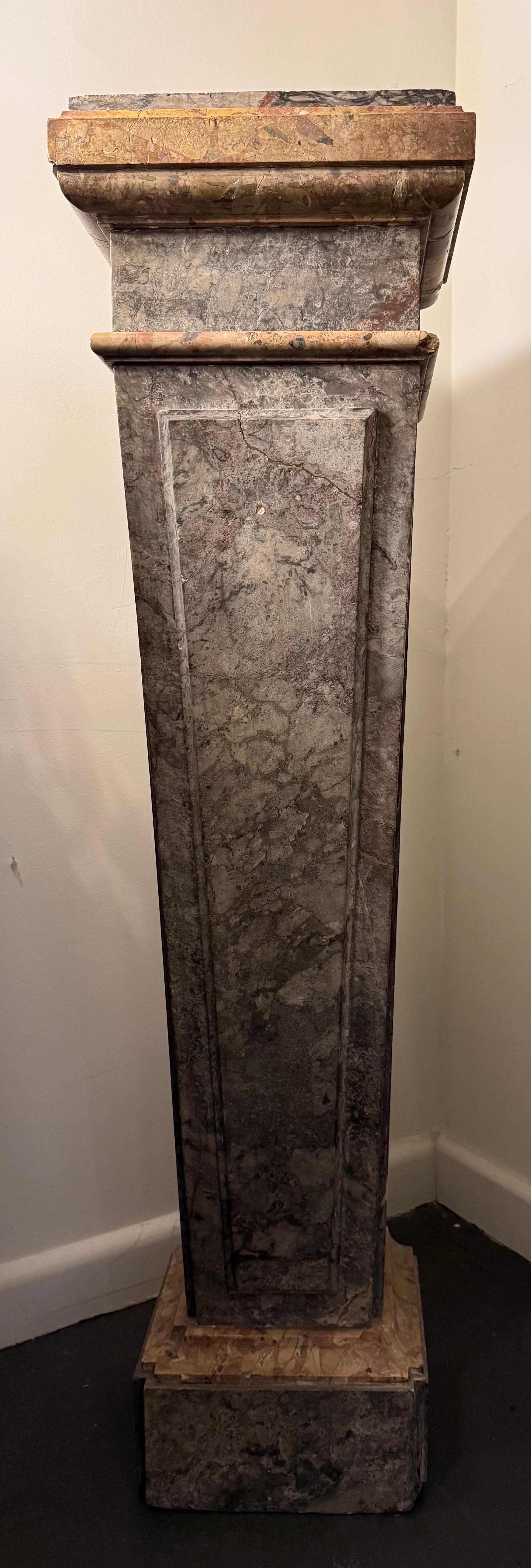 A Tapered Square Marble Pillar, 19th Century

The square moulded capital of the pillar above a deep neck and a pulvinated astragal, the tapered shaft with a raised panel of conforming shape to the front, descending to a scotia and shallow plinth