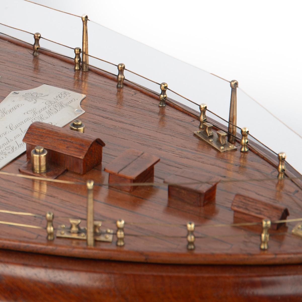 A Teak Model of the Stern of HMS Howe, Presented to Captain Assheton Gore Curzon Howe in February of 1892

A teak model of the stern of HMS Howe adorned with brass cannons and deck fittings, white ensign and a plaque which reads as follows

“The