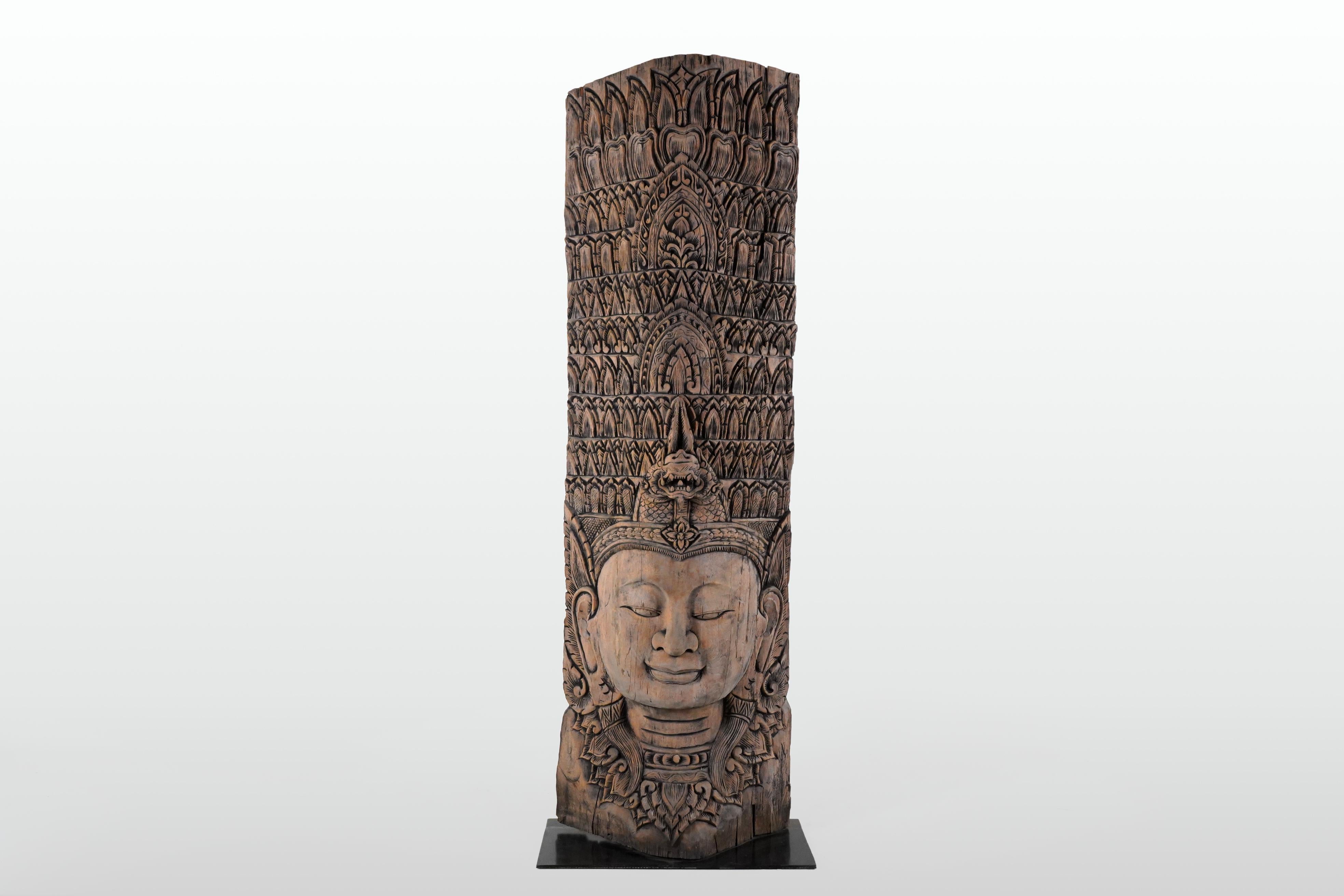 Récemment sculpté dans du teck recyclé, ce buste prend la forme d'une Apsara. Issues des mythologies hindoue et bouddhiste, les Apsaras sont des esprits féminins des nuages et des eaux. Elles sont également appelées 