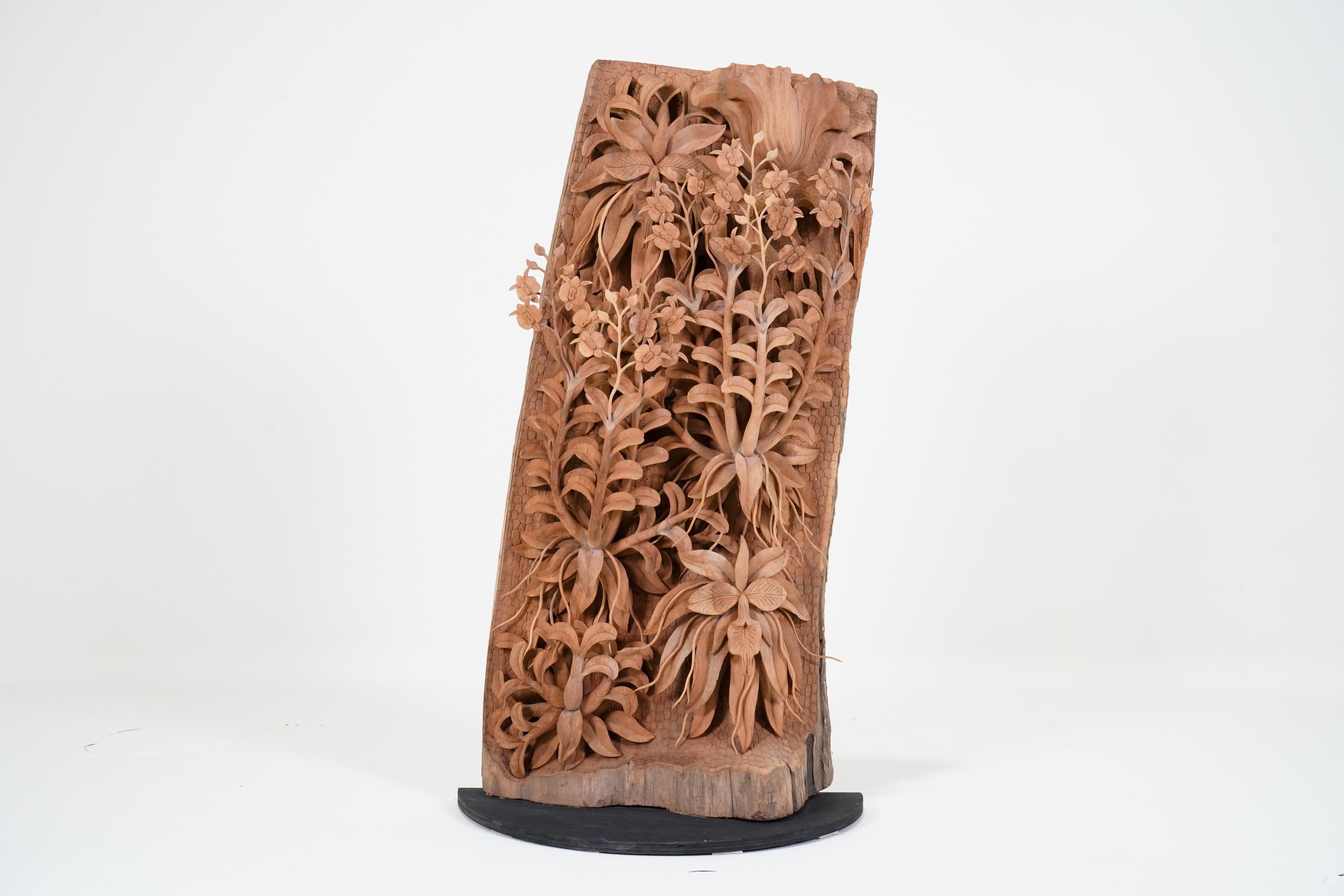 This extraordinarily life-like sculpture depicts orchids growing in the Asian forest.  Thai wood carvers are very adept at carving teakwood into countless forms, including religious sculptures, elephants, fretwork panels, furniture and more.   Teak