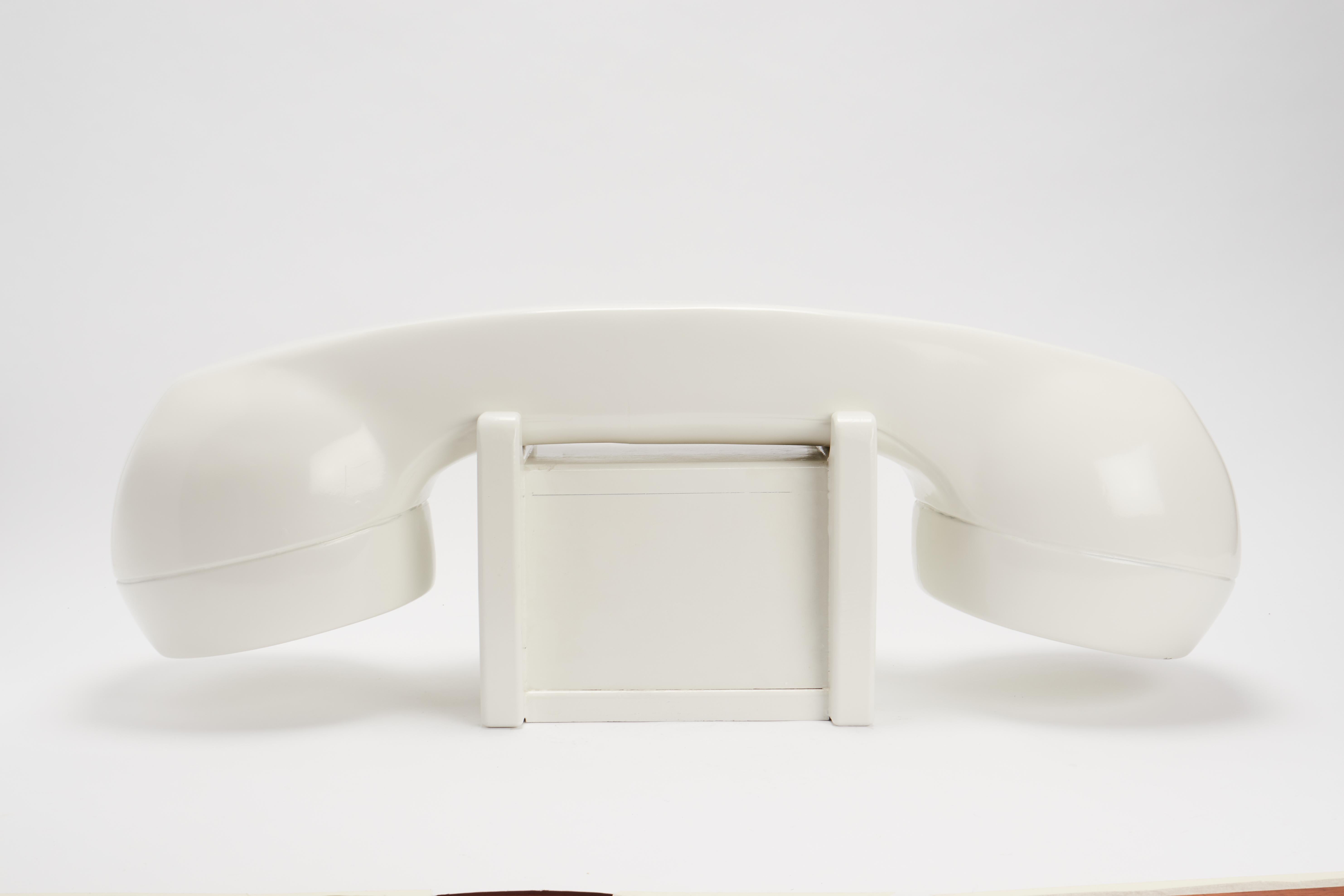 Ein Schaufensterschild einer amerikanischen Telefongesellschaft, auf dem ein großes Telefon abgebildet ist. Aus Obstholz geschnitzt und mit weißer Emaille bemalt. USA 1950 ca.