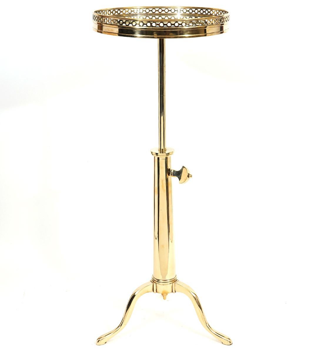 This French Maison Toulouse telescoping brass occasional tables, dating to around 1970 and retailed by John Boone NY, feature circular pierced gallery tops with inset mirror supported by an adjustable telescoping shaft and cabriole legs with pad