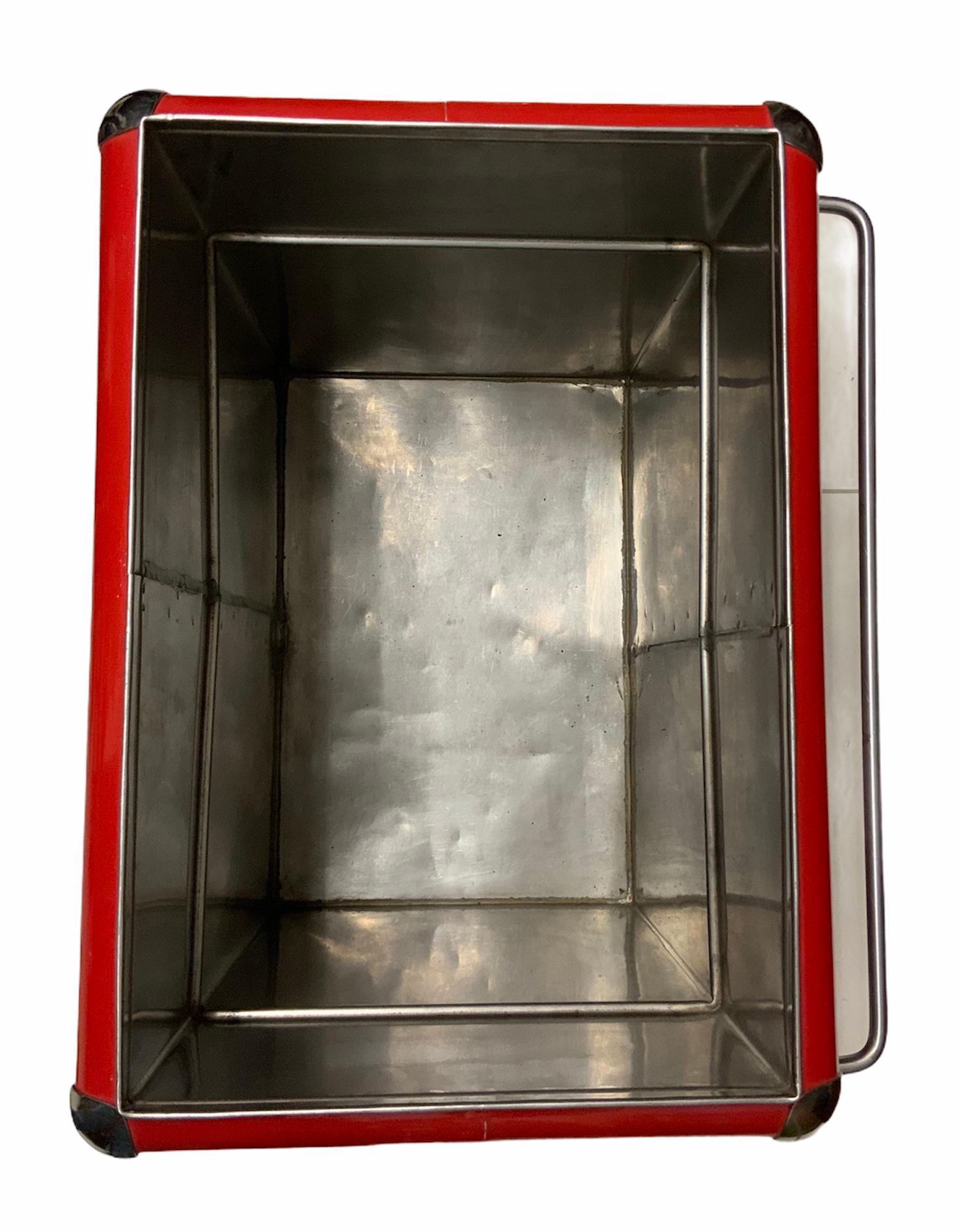 This a red large rectangular metal Coca Cola cooler with two handles. There is an upper compartment when you open the lid and below it, there is a large deep compartment for the Coca Cola sodas. A great piece for Coca Cola’s collector. The Coca Cola