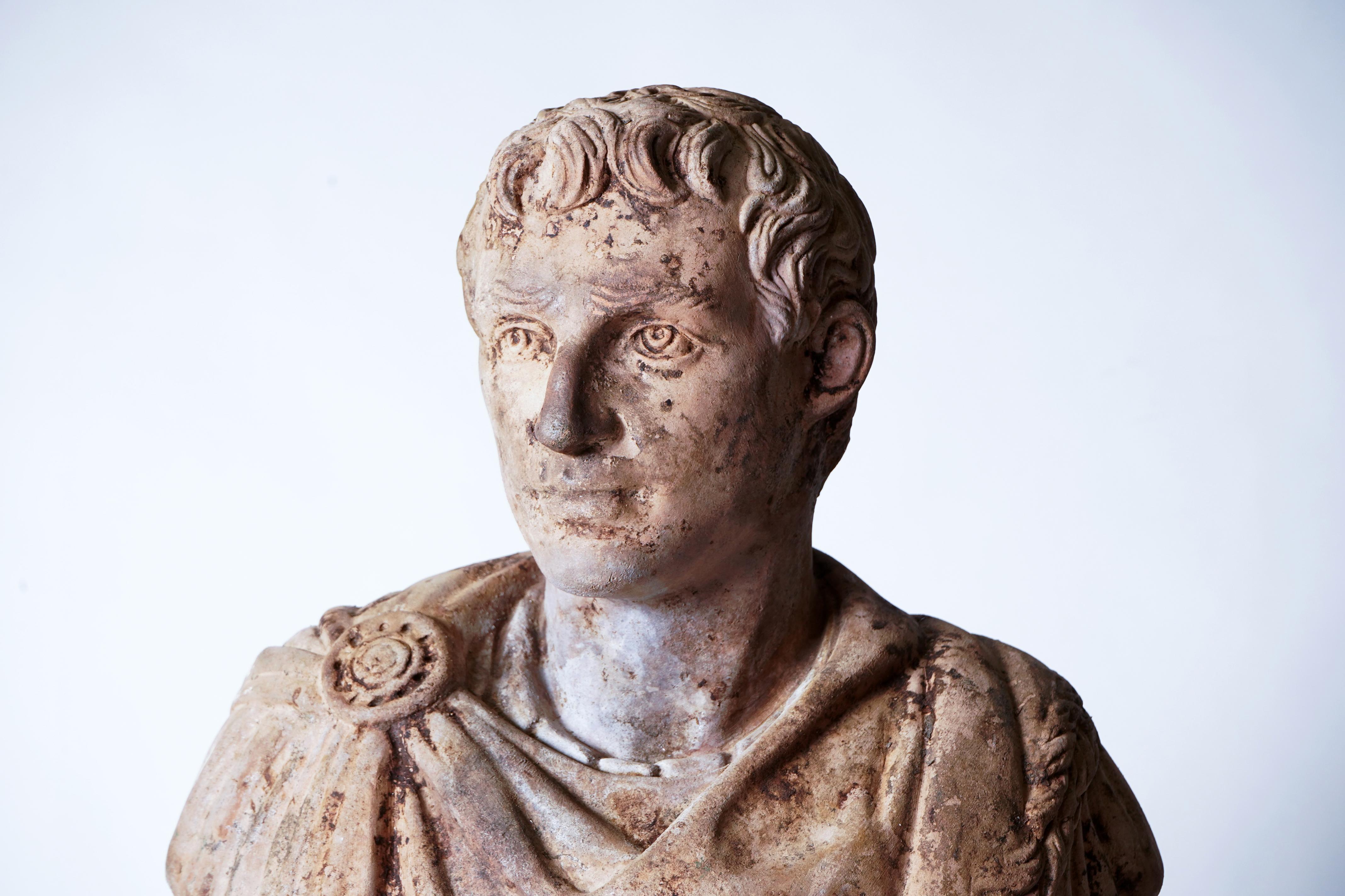 This 20th century bust of a Roman emperor is made from terra cotta and has the discoloration and patina that comes from outdoor use.
 