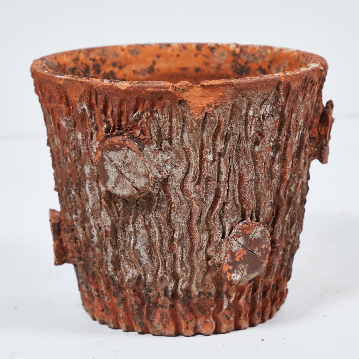 A terracotta pot in the shape of a tree trunk with decorated bark from Watson's Supermarket in England, circa 1950.