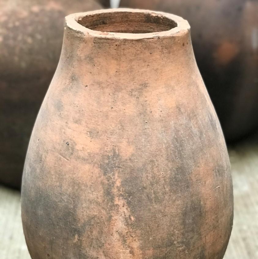 Poncho is a vintage terracotta vessel discovered in a potters studio in the region of Jalisco, Mexico. This piece has soft rounded lines with an edged rim that helps break those lines in an elegant way. The dark tones and agenda patina make this a