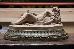 A Terracotta Group of a reclining scantily clad maiden with her dog