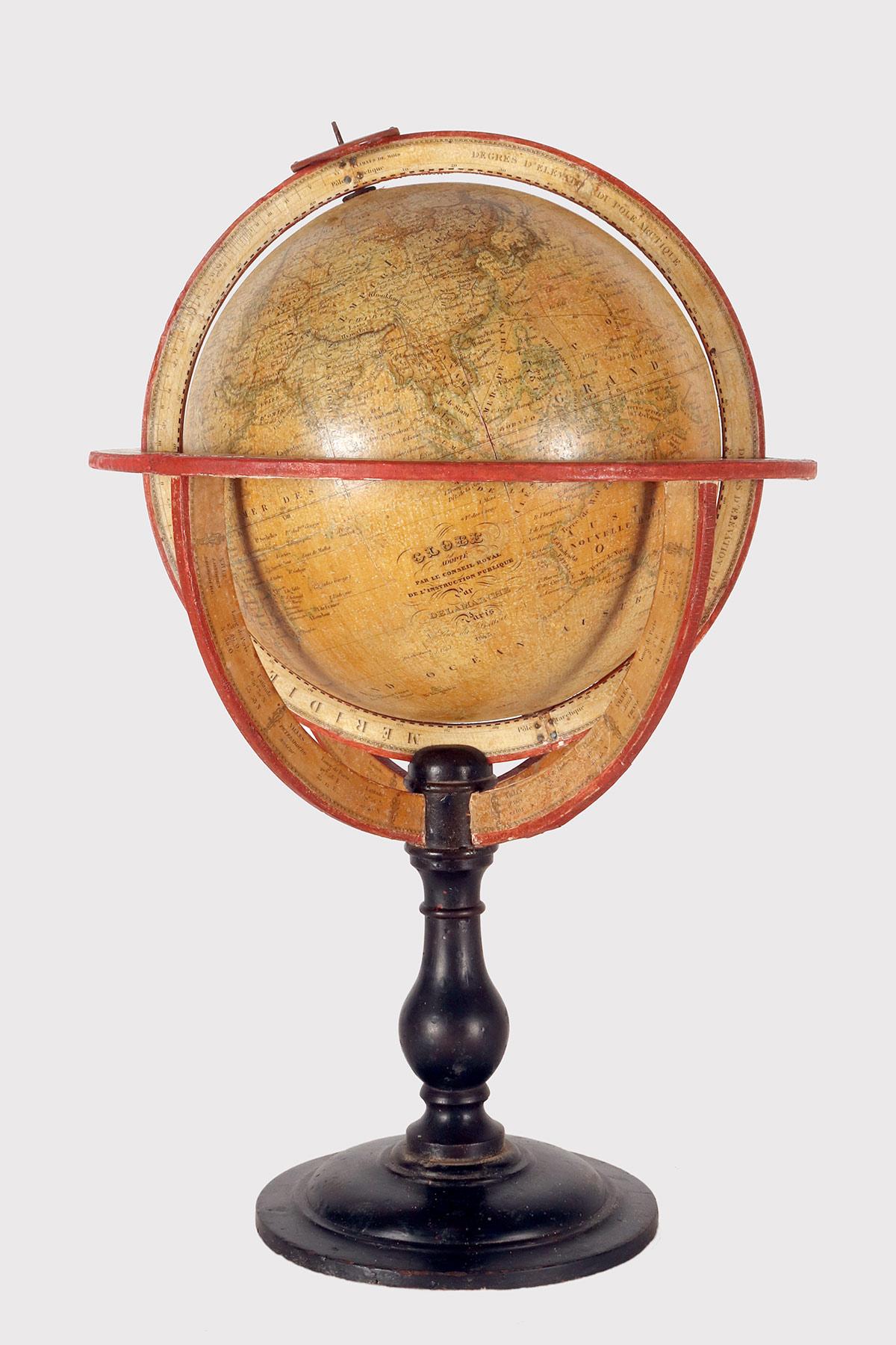 Engraved wooden and paper maché globe. Equator resting on four quarter meridians on a turned black fruit wooden base with moved profile and circular base.
The globe is composed of twelve copper printed paper gores, juxtaposed and glued onto a sphere