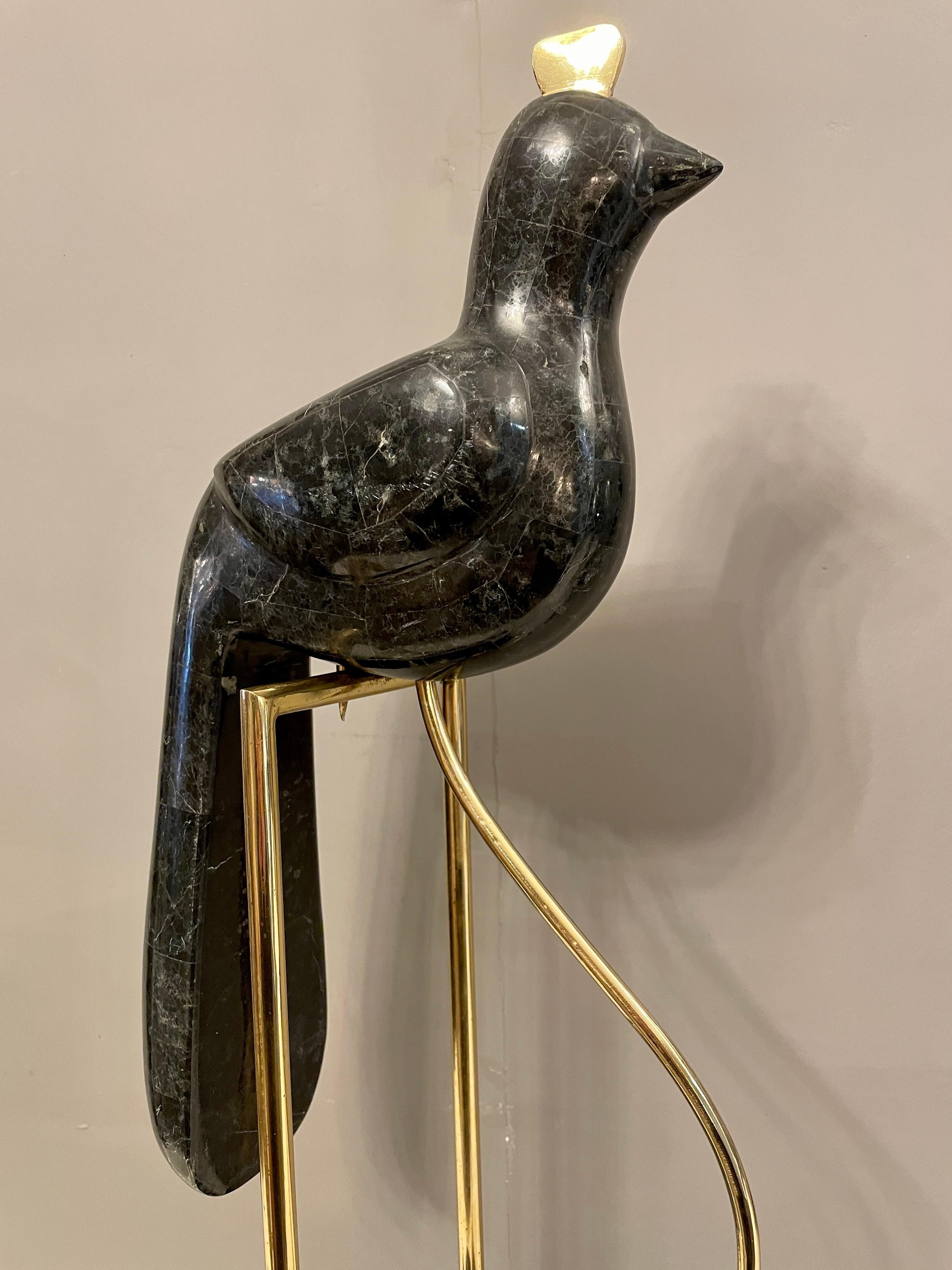 A black tessellated bird perched and counterbalanced on a brass stall again with tessellated marble base

By Maitland Smith 

Circa 1970.