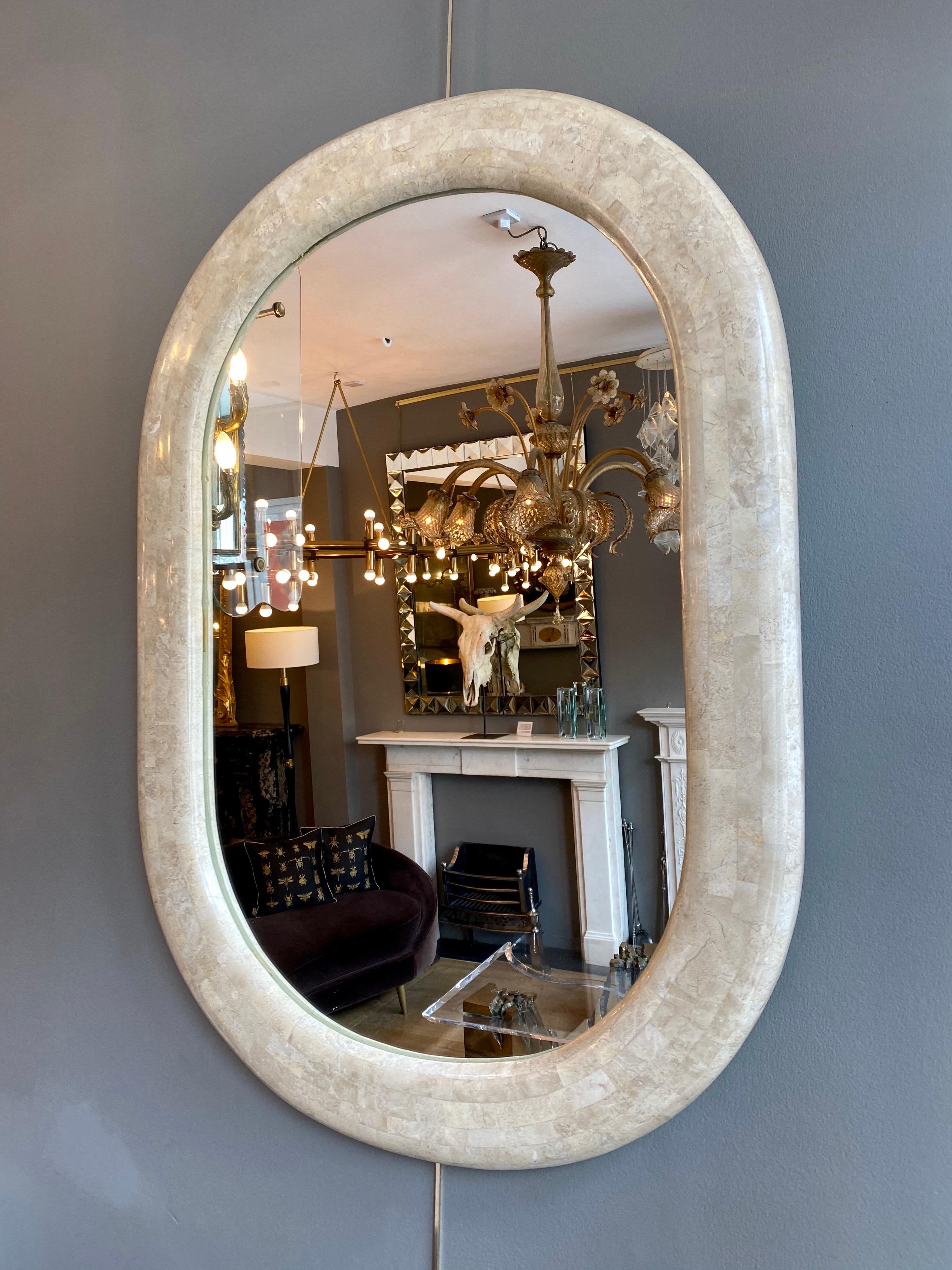 A good sized wall mirror in a natural colored tessellated stone. The frame with curved and rounded edges. Maitland Smith, late 20th century, USA. Also available is a matched console table by the same designer/manufacturer 