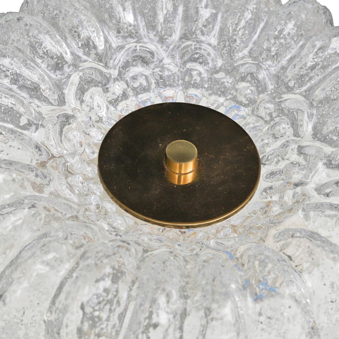 Lámpara de techo empotrada vintage fabricada por Glashütte Limburg en Alemania durante la segunda mitad del siglo XX. La lámpara tiene una tulipa de cristal transparente grueso y texturizado con una forma festoneada, casi floral, que difunde la luz
