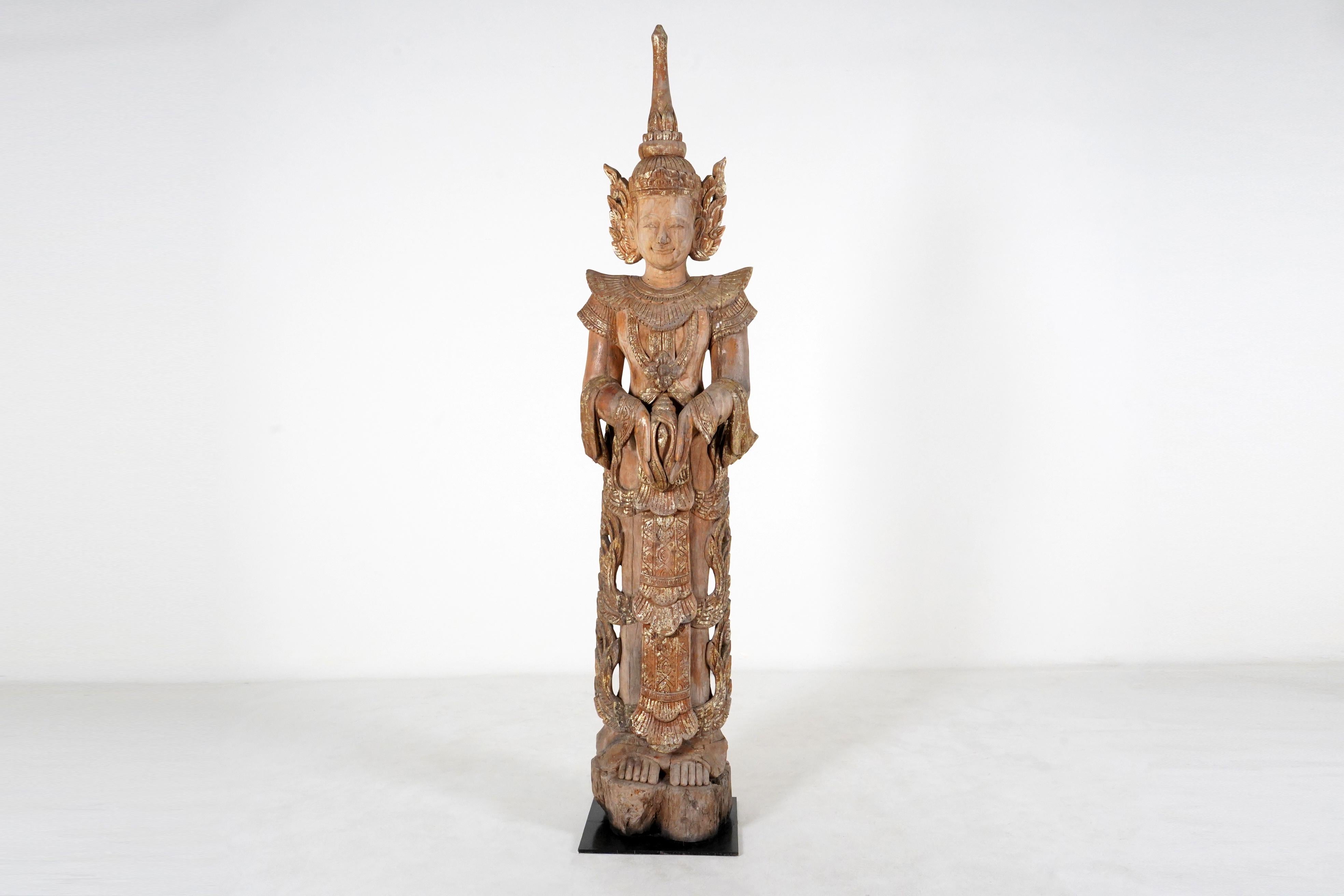 Thai temples contained various kinds of carved figures including Buddhas, apostles and angels. This large blessing angel is based on sculptures that flanked altars or entrances. Thai Buddhists, like members of other faiths, believe that benign