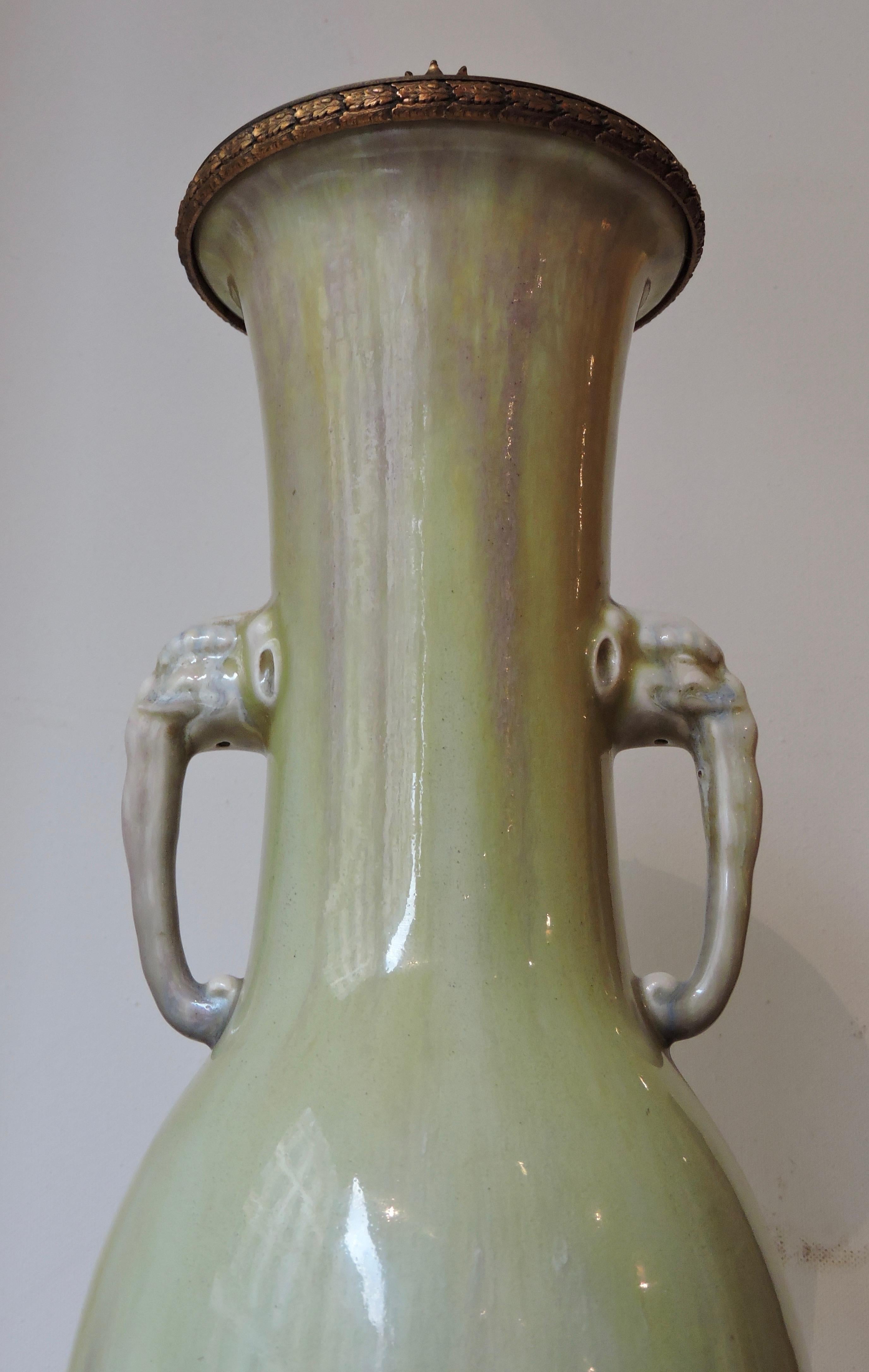 A Theodore Deck (1823-1891) Celadon Enamelled Faience Vase Ormolu-Mounted in Lamp
circa 1870.
The neck adorned with two symmetrical elephant heads handles.
Th.Deck impressed uppercase mark
Fitted for electricity.
 
