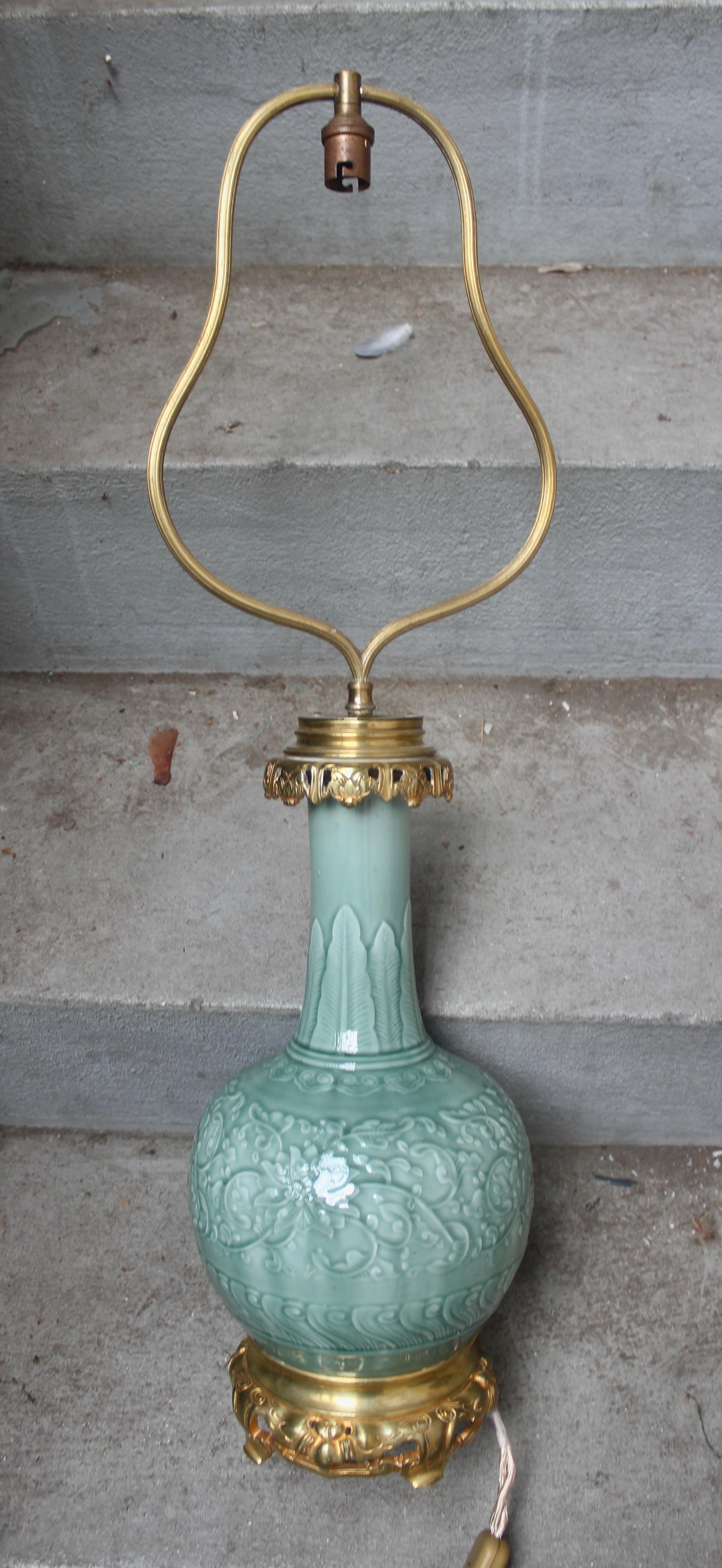 An ormolu-mounted Theodore Deck (1823-1891) celadon enameled faience vase mounted in table lamp,
circa 1880,
Bottle form, molded with scrolling lotus, the neck with stiff-leaf tips,
Fitment with plaque Gagneau / 115 / R. Lafayette
Shade
