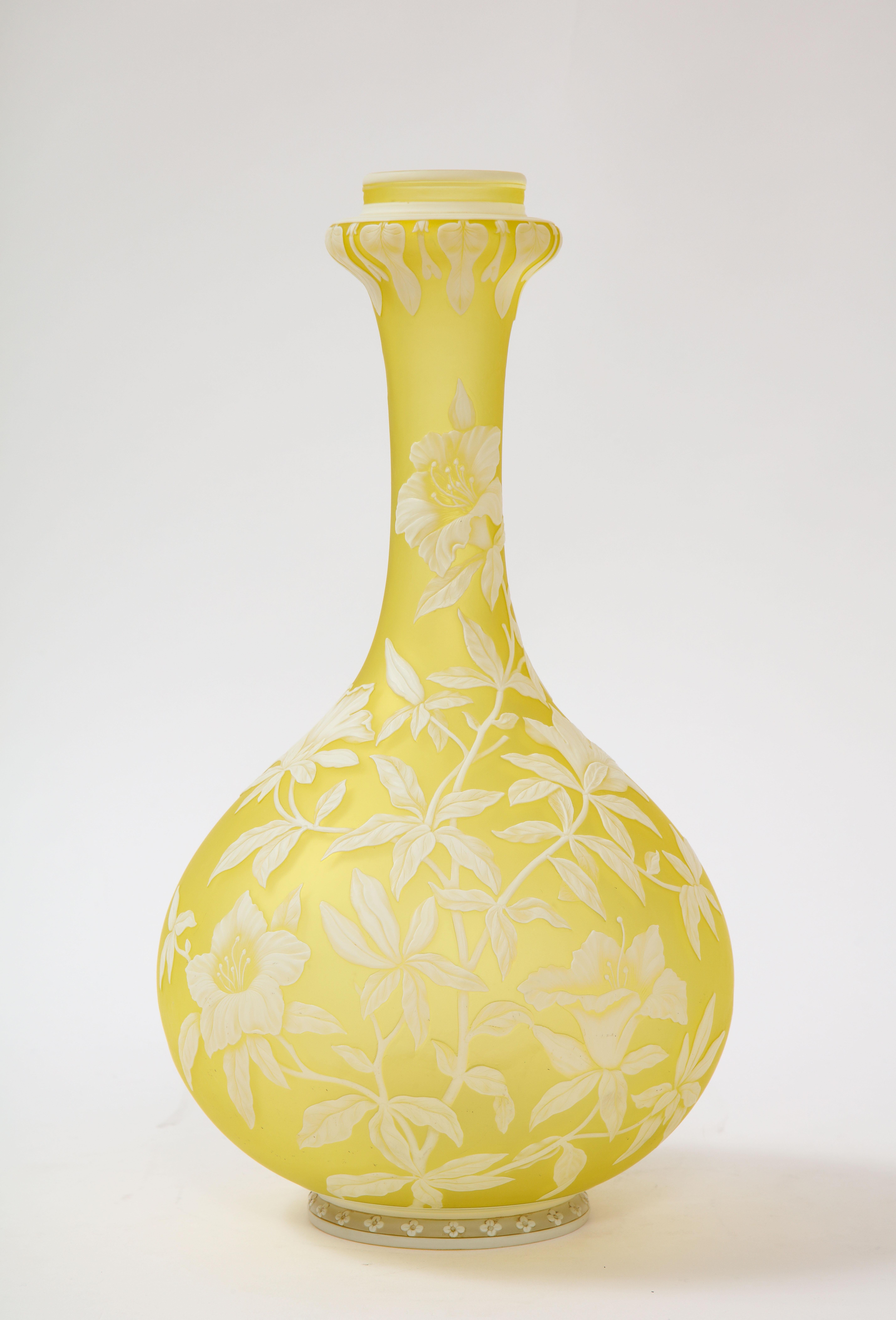 An incredible quality Thomas Webb & Sons cameo double overlaid white over yellow etched and acid washed vase. This particular vase is of a yellow ground with white overlaid flowers, leaves, and vines hand carved into it. The entire vase is