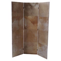A three panel dark parchment covered folding screen, Contemporary