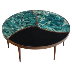 A three-part biomorphic marbleized glass and walnut circular coffee table.
