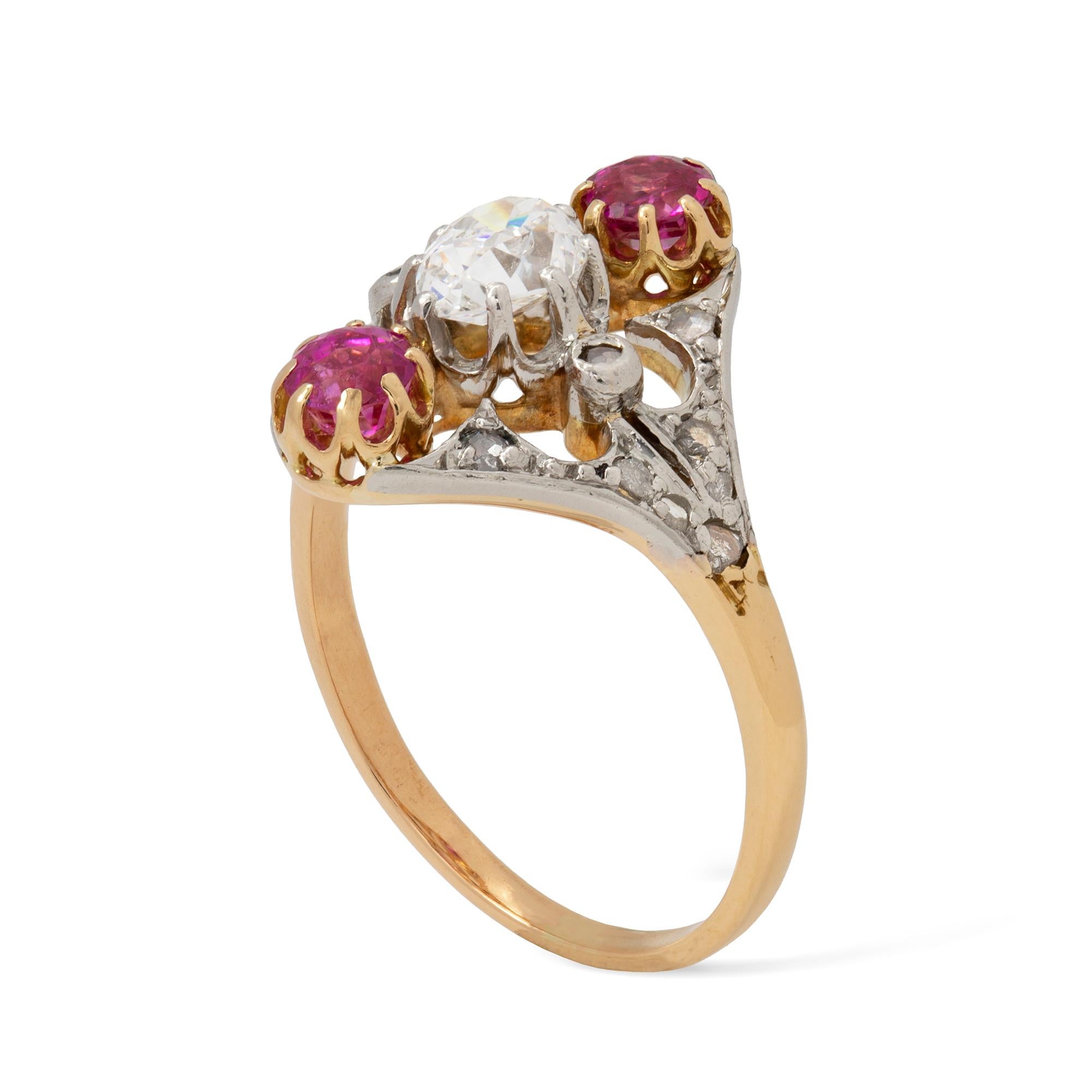 A three stone diamond and pink sapphire ring, the old pear-shaped diamond estimated to weigh 0.4 carats, vertically-set between two round faceted pink sapphires, estimated to weigh 0.4 carats in total, to rose-cut diamond set split shoulders, all