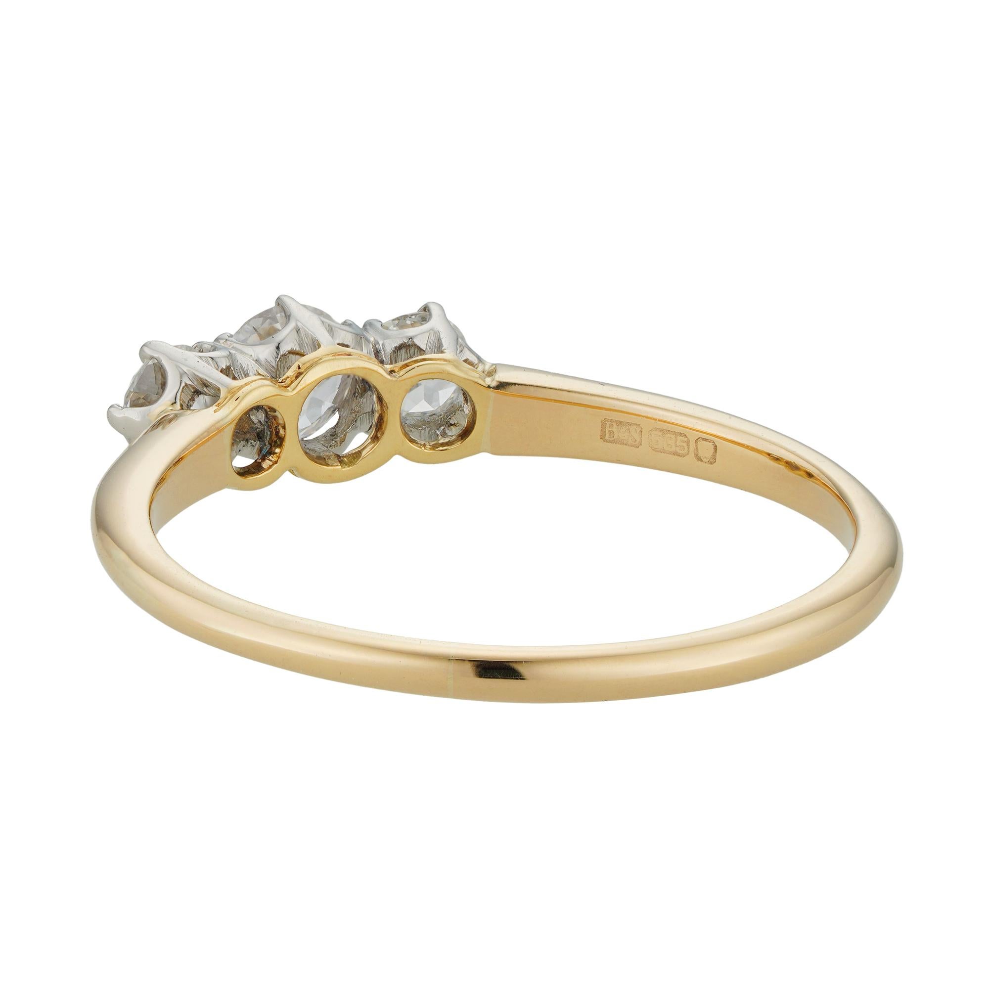 A three stone diamond ring, the three old European-cut diamonds weighing 0.39 carats in total, claw-set to white gold collets with openwork gallery, to a yellow golf D-section tapering shank, circa mid-20th century, later hallmarked London, 14ct