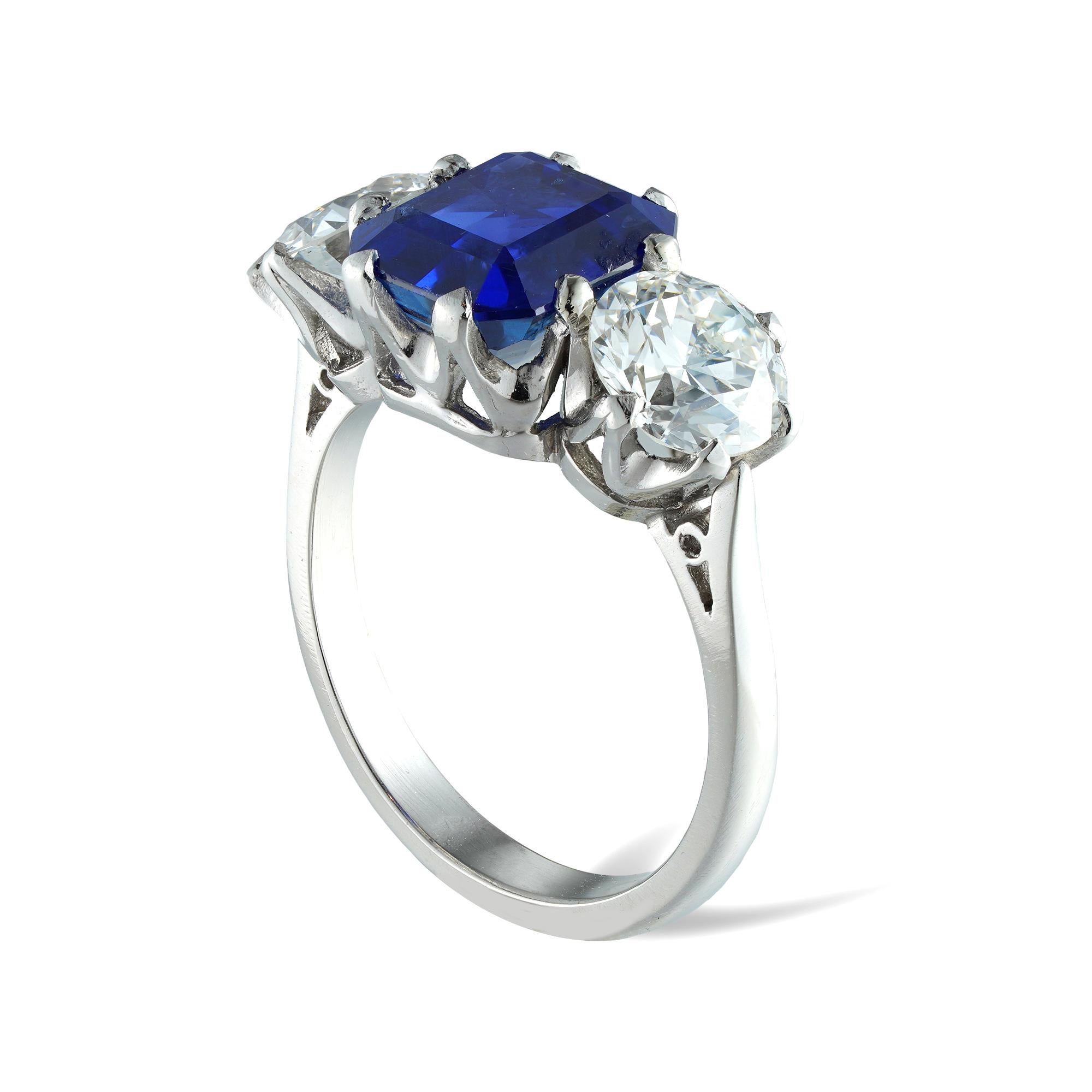 A three stone sapphire and diamond ring, the emerald-cut sapphire weighing 4.56 carats, accompanied by GCS Report  stating to be of Sri-Lankan origin with no indication of heating, set between two old-European-cut diamonds weighing 2.24 carats in