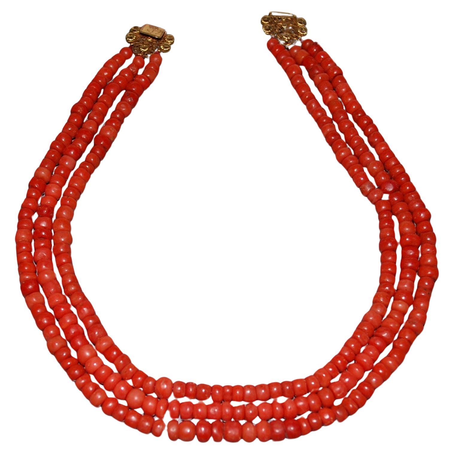 Stunning antique Coral necklace.
A three strand of fine European natural red/salmon coral  necklace beads about 5-6mm. The coral beads are barrel-shaped and the handmade clasp is made of 14k yellow gold. The clasp is absolutely gorgeous with