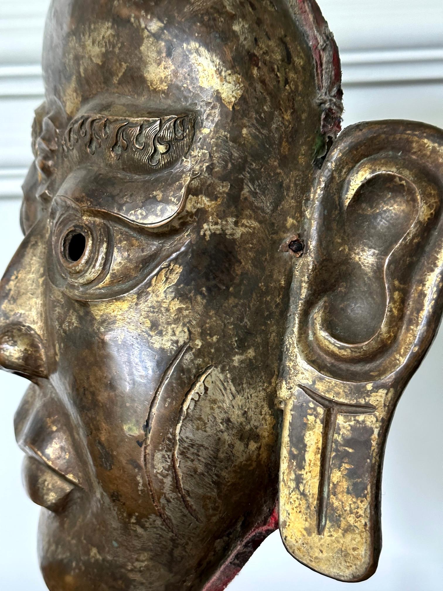 Maschera tibetana in lega di rame dorato su espositore in vendita 7