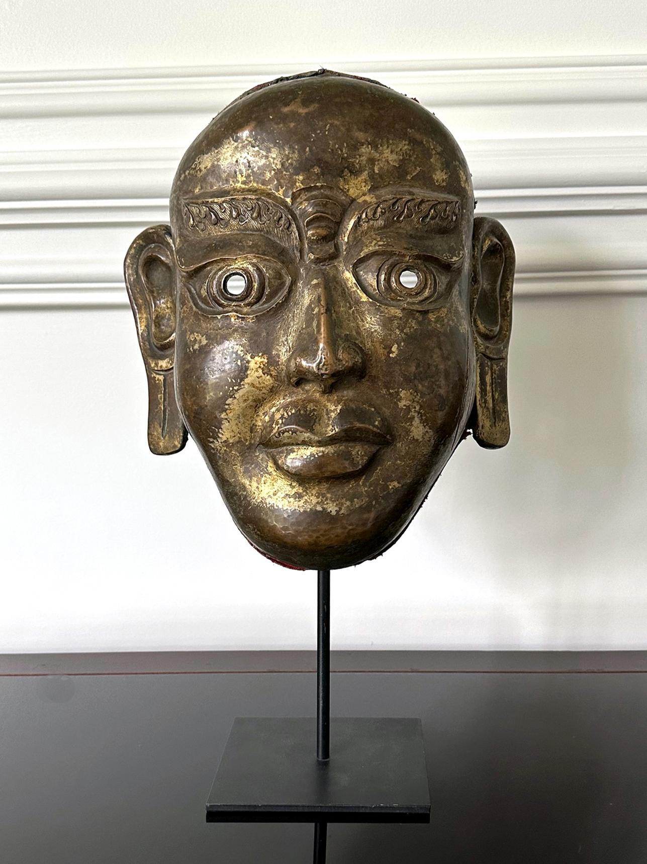 An impressive copper alloy mask of Arhat, the disciple and follower of Buddha (also known as Luohan in Chinese) from Tibetan region circa 19th century. The larger-than-life mask has striking iconic facial features: large, rounded eyes under bushy