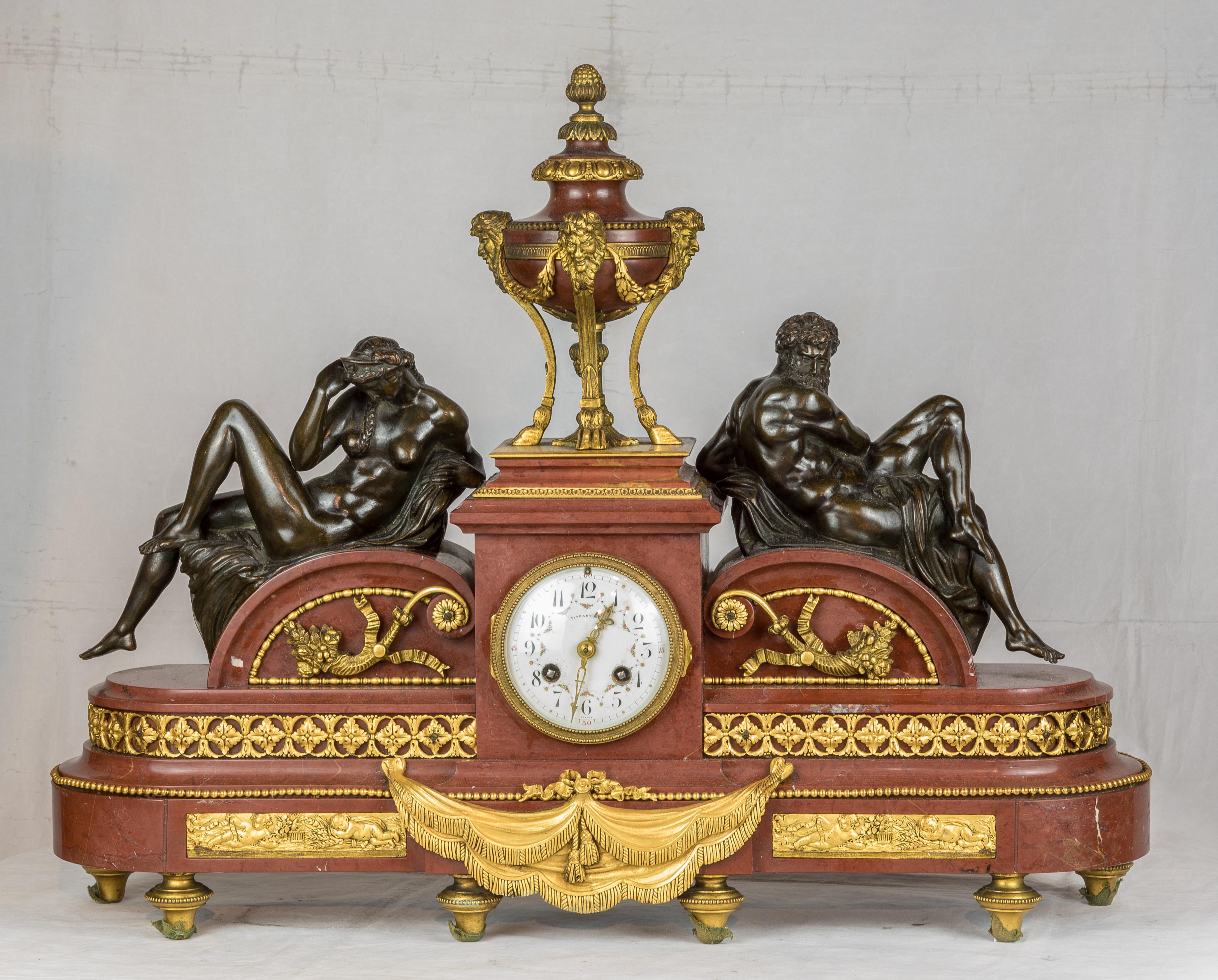 A Tiffany & Co. gilt bronze and rouge marble mantel clock with figures of night and day

Maker: Tiffany & Co. (American, 1837-)
Date: Circa 1890
Dimension: 18 in. x 24 in.
