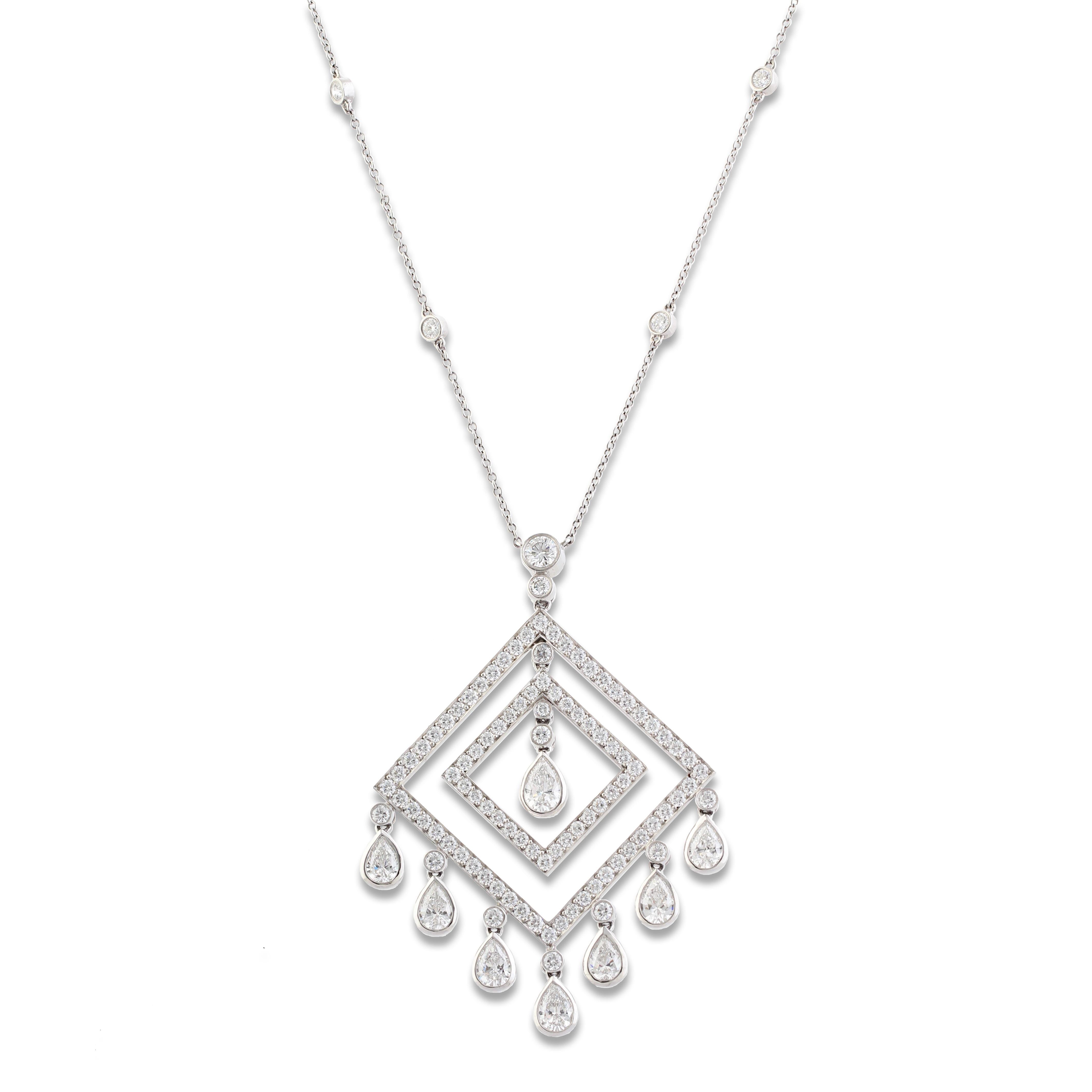 A stunning set by Tiffany & Co consisting of a platinum and diamond lozenge design pair of earrings and pendant necklace. The earrings and pendant are set with delicate pear shape diamond drops and the pendant hangs from a very fine platinum chain