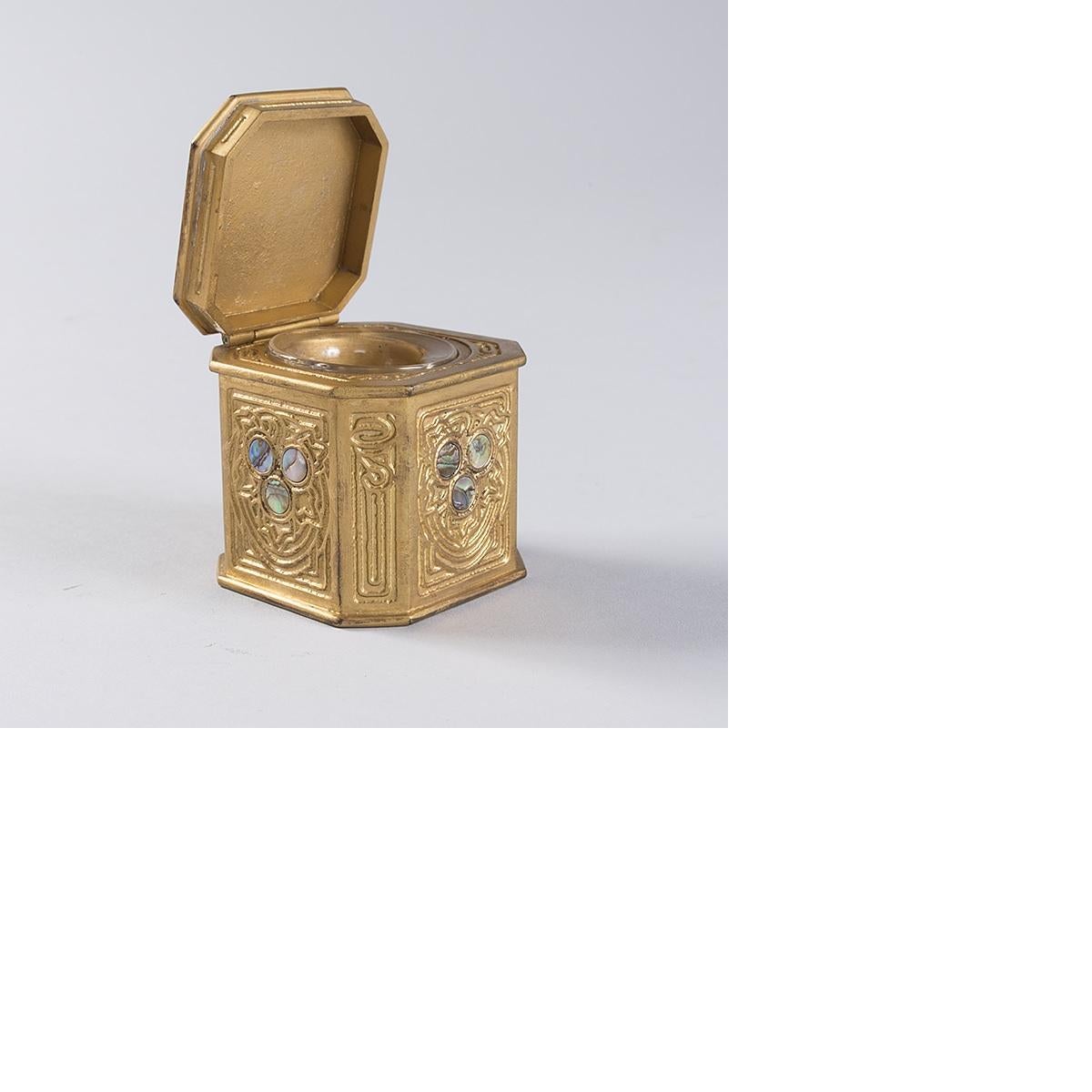 A Tiffany Studios New York gilt bronze and abalone inkwell, circa 1900.

For the desk set: pieces in the 